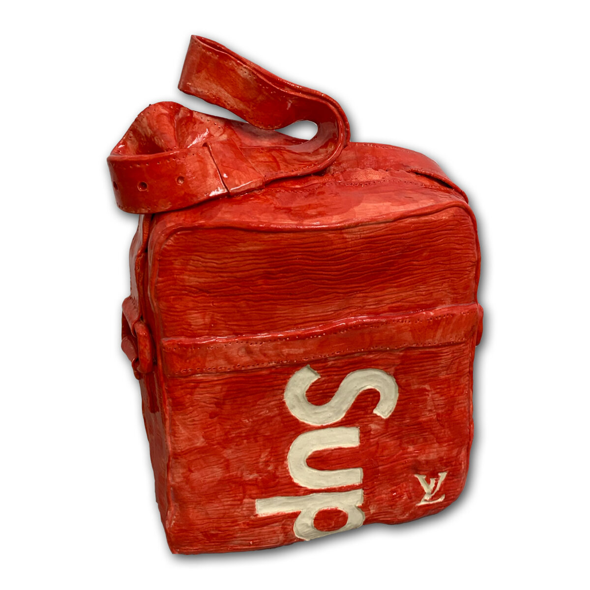 A bright red ceramic shoulder bag with a curved handle, featuring white lettering and a designer logo on its front face. The textured glazed surface mimics the appearance of worn leather or fabric with visible brushstrokes and dimensional relief throughout.