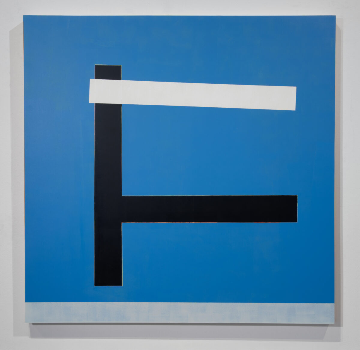 Abstract geometric composition featuring a vertical black rectangle intersected by a horizontal white band against a bright blue background, with a smaller black horizontal element below, on a wooden panel with subtle shadow effects.