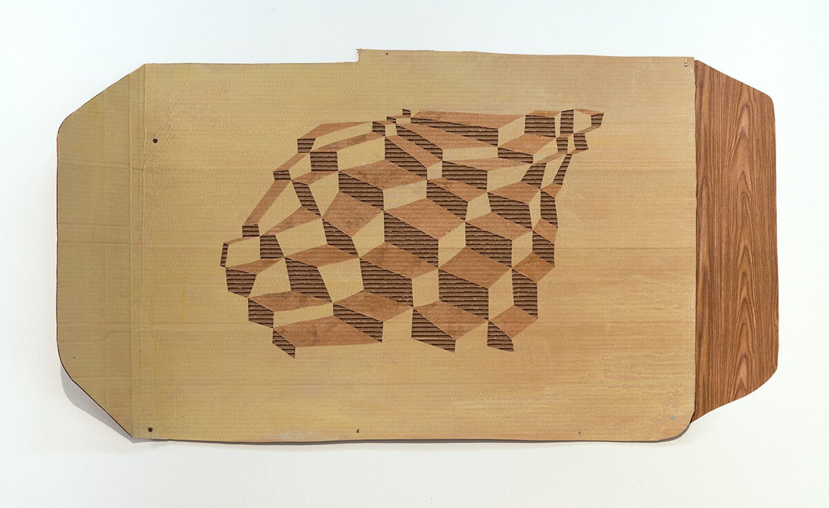 Wooden relief panel featuring an isometric cubic pattern carved in varying depths, creating a three-dimensional optical effect through contrasting light and dark wood tones. The pale rectangular board is mounted against a white background with visible fasteners along its edges.