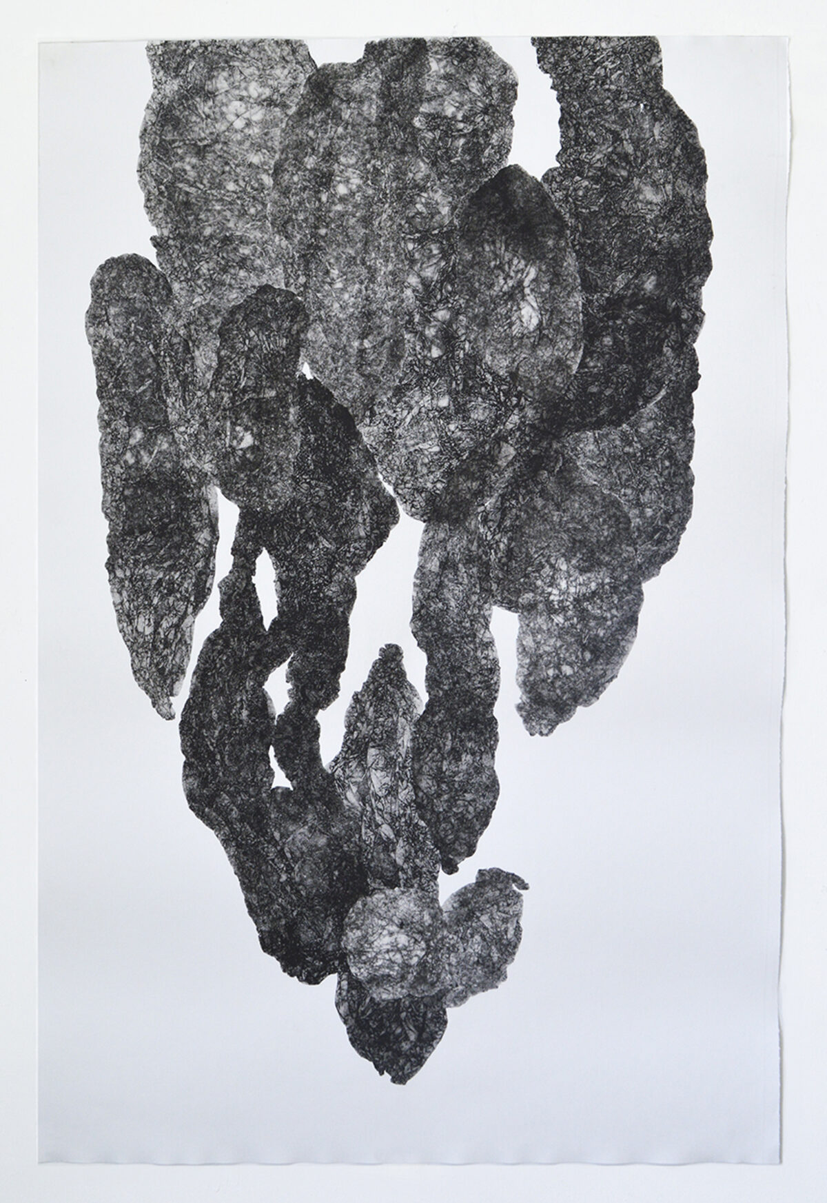 A textured, dark gray monoprint on white paper depicting an abstract, vertical form composed of layered, organic shapes with rough, granular surfaces. The composition suggests fragmented or stacked geological formations, with lighter areas creating depth and contrast throughout the composition.