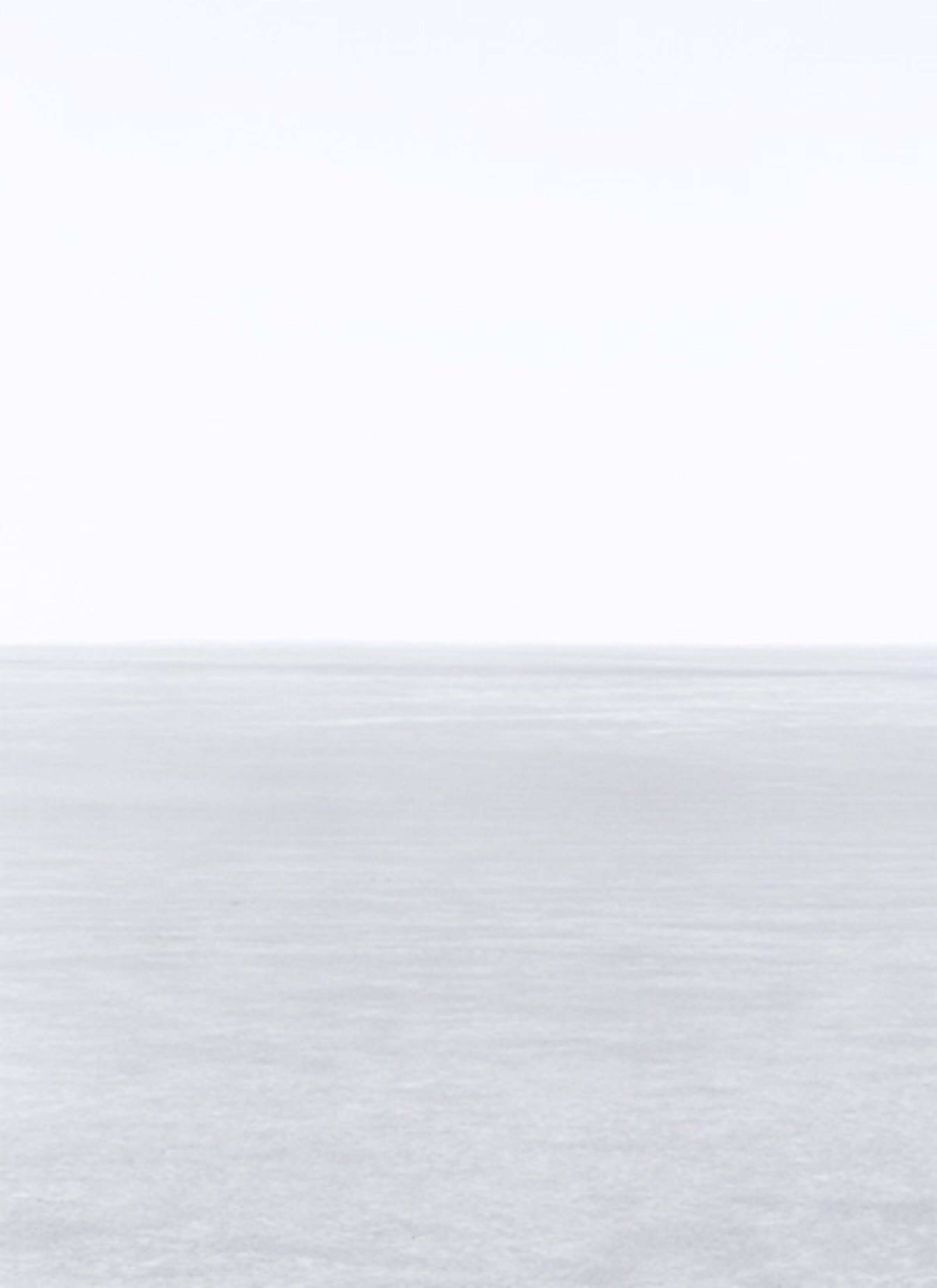 Minimalist landscape divided horizontally into pale sky above and textured white-grey ground below, with a subtle horizon line creating a stark, contemplative composition in soft, muted tones.