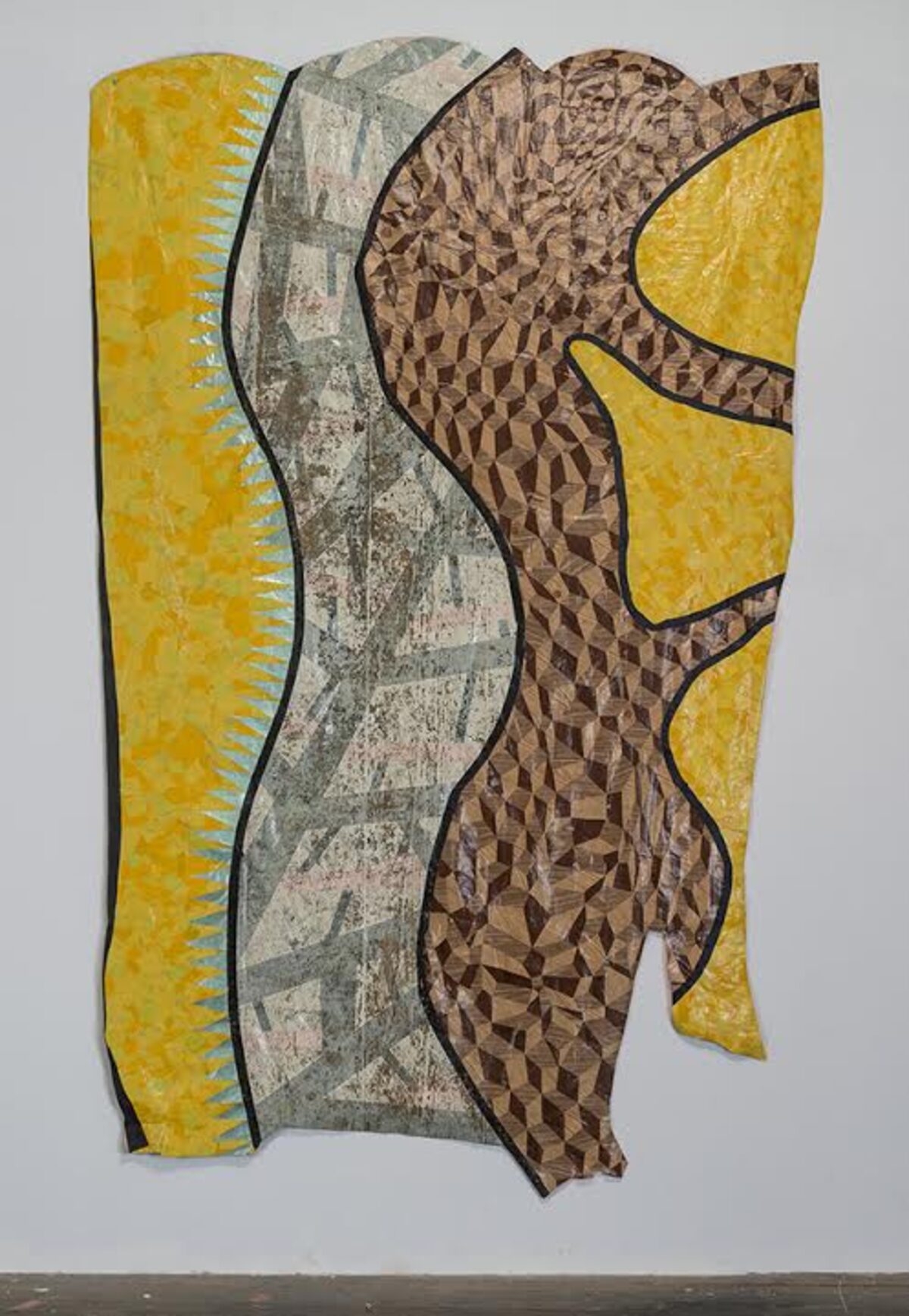 Abstract mixed-media composition featuring layered strips of patterned and textured materials in yellow, gray, and brown tones, arranged vertically with undulating edges and black outlines creating a dynamic, sculptural quality against a white wall.