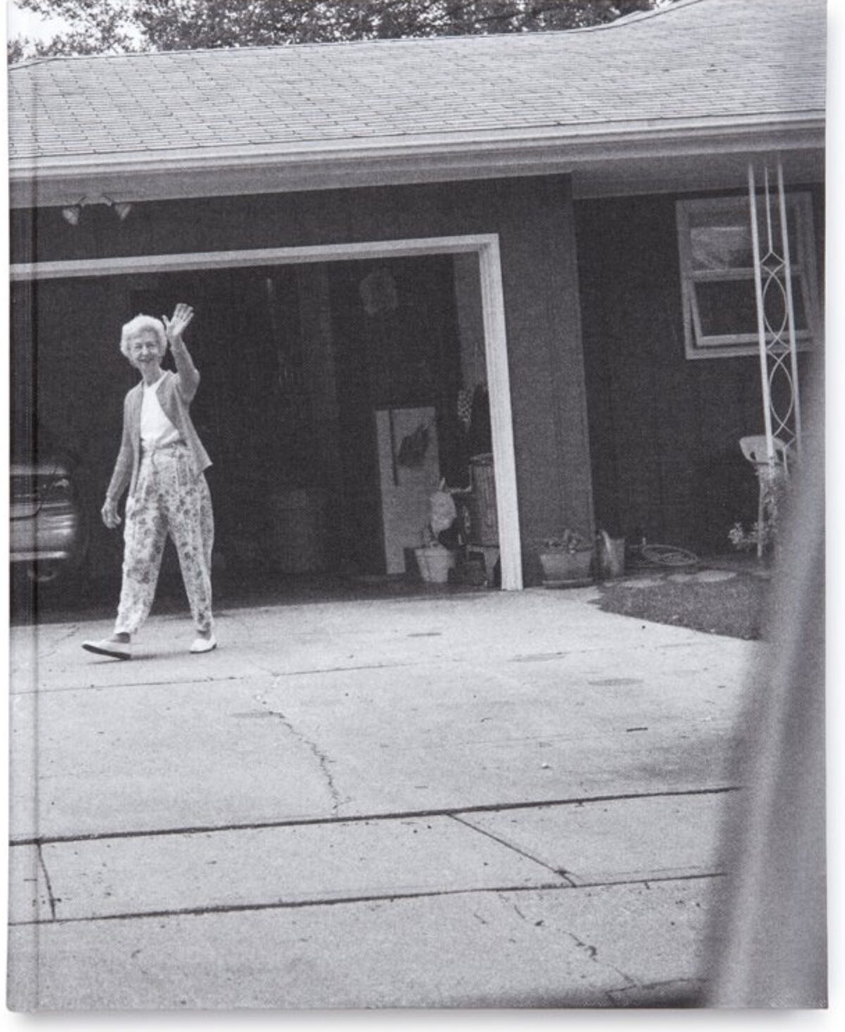 Front cover of Leaving and Waving by Deanna Dikeman, showing a black-and-white photograph of her parents outside their home.