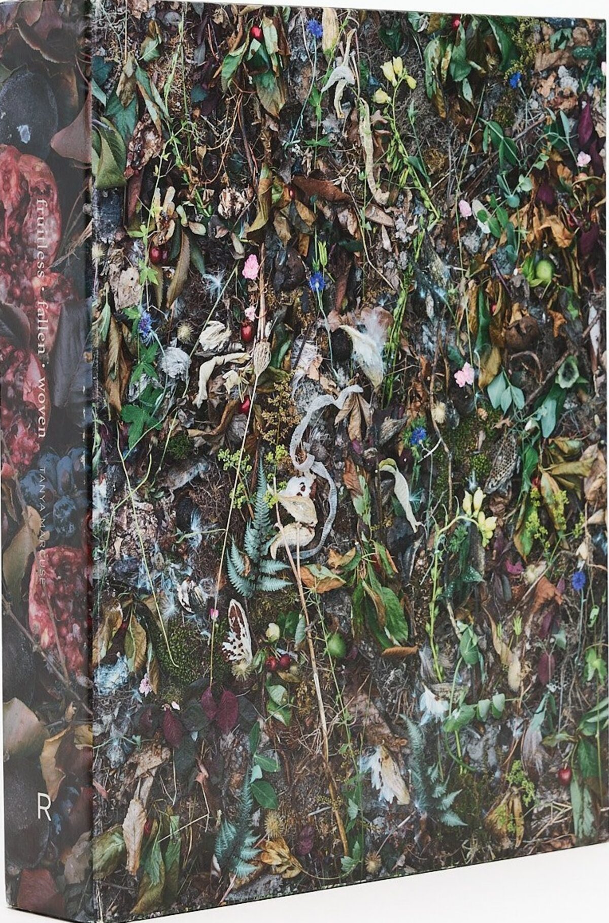 Slipcase for Fruitless | Fallen | Woven by Tanya Marcuse, photographed at an angle, covered in densely arranged plants, fruit, and organic material.