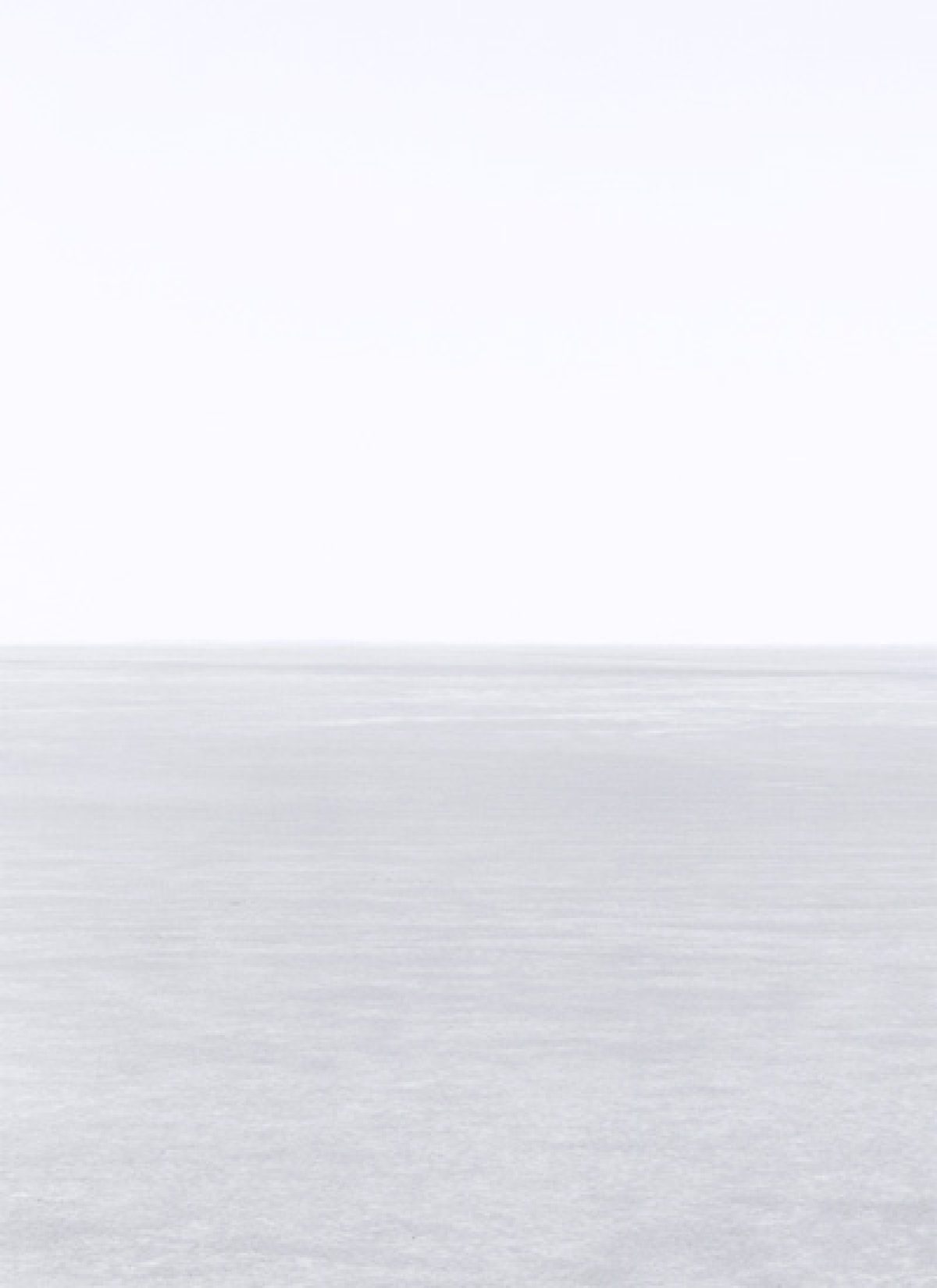Minimalist landscape divided horizontally into pale sky above and textured white-grey ground below, with a subtle horizon line creating a stark, contemplative composition in soft, muted tones.