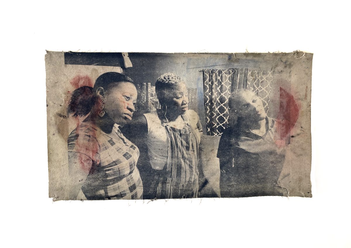 Faded black and white photograph of four Black women in an interior space, overlaid with translucent red and pink gestural marks. The photograph is aged and weathered with visible creasing and discoloration, mounted on a light background.