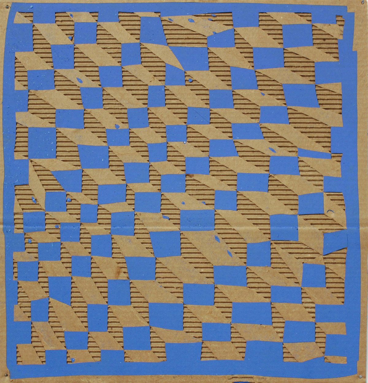 A checkerboard pattern of bright blue and tan squares covers a cardboard surface, with diagonal linear textures visible across the tan sections. The blue squares form a clean geometric grid while the underlying corrugated cardboard shows through in places, creating areas of visual depth and weathered abstraction.
