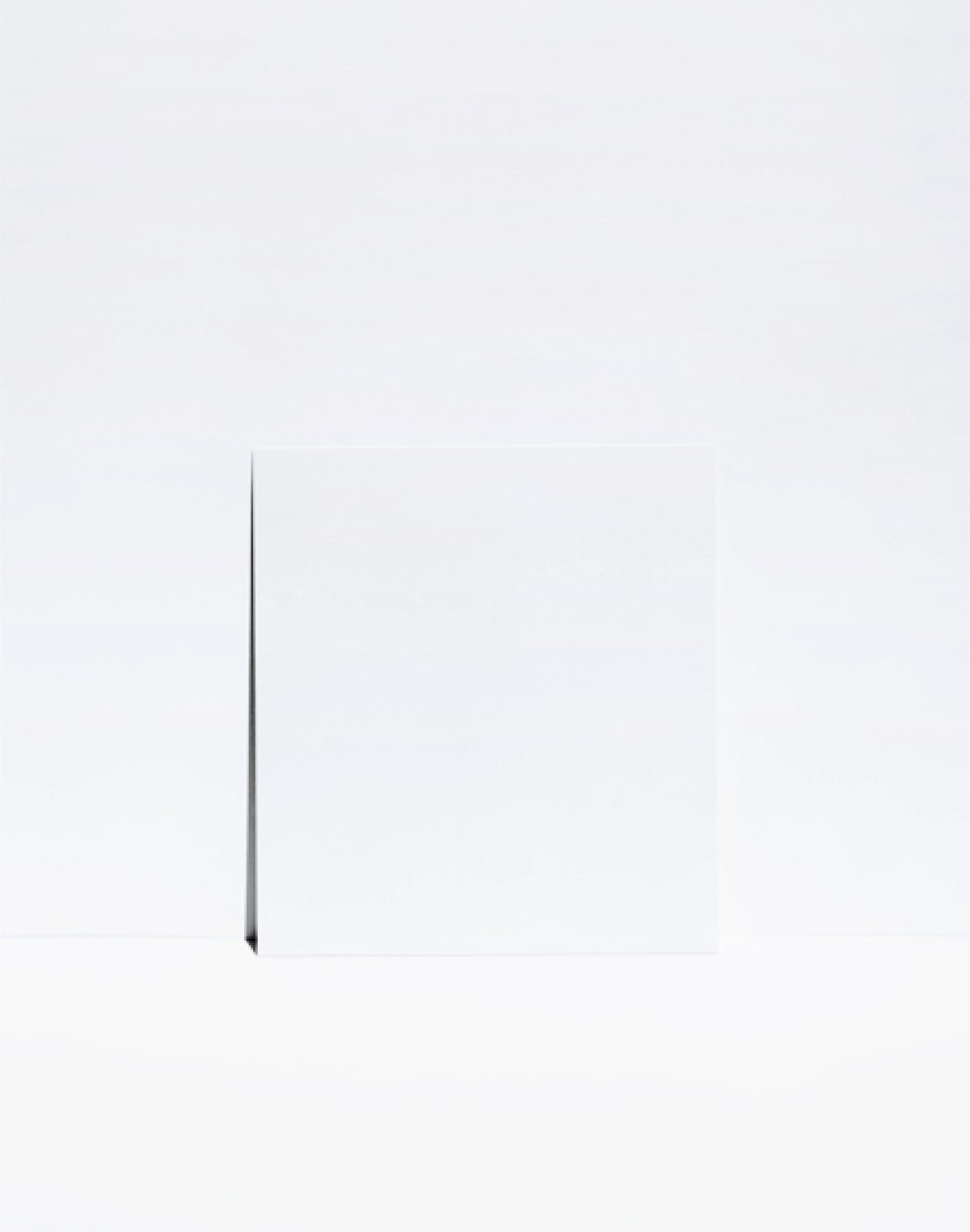 A minimalist composition featuring a single dark diagonal line extending from the lower left toward the upper center of a predominantly white field. The austere arrangement emphasizes negative space and subtle tonal variations across the pale background.