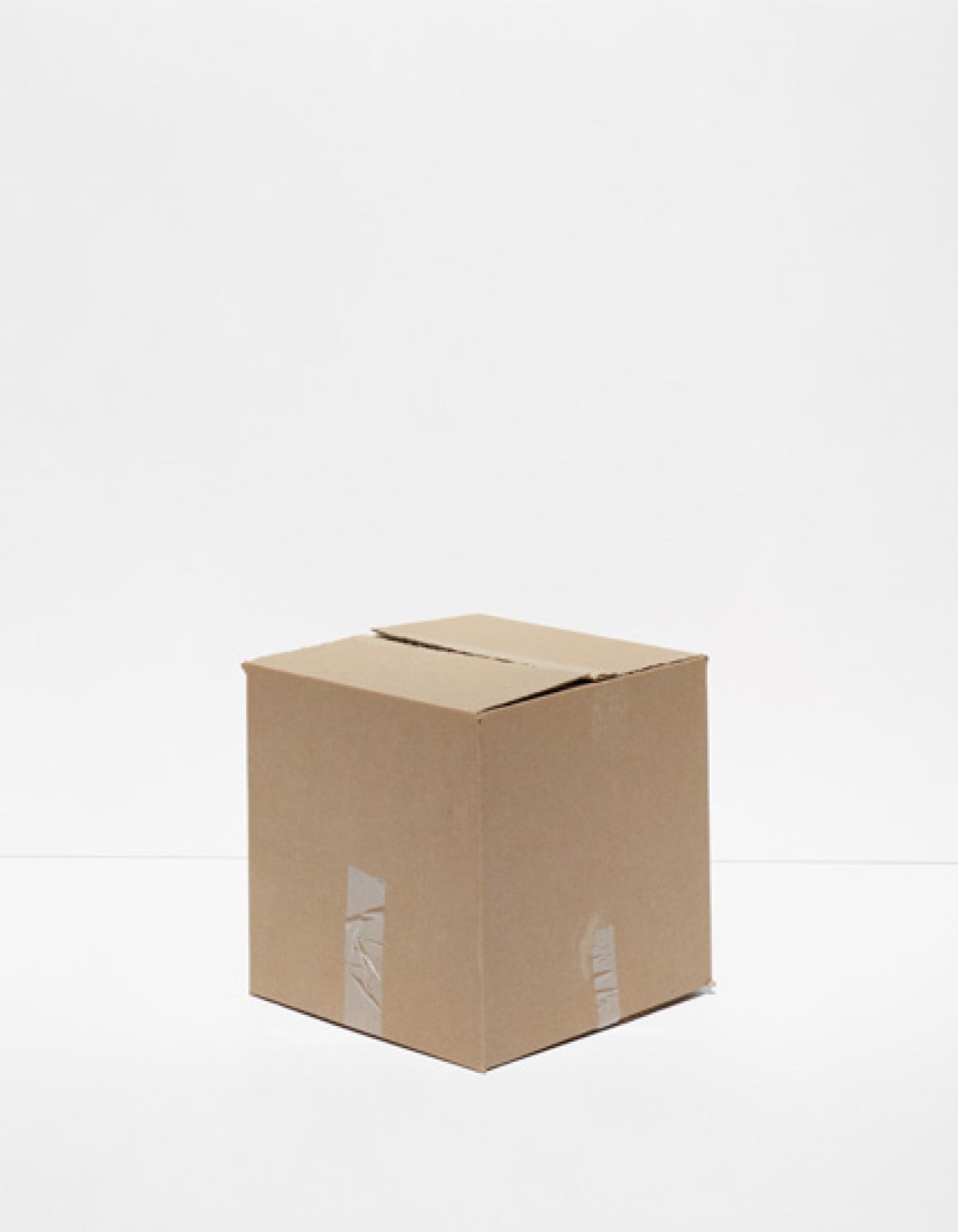 A tan cardboard shipping box photographed centrally against a neutral gray background, with visible clear packing tape on two sides and a slot cut into the top.