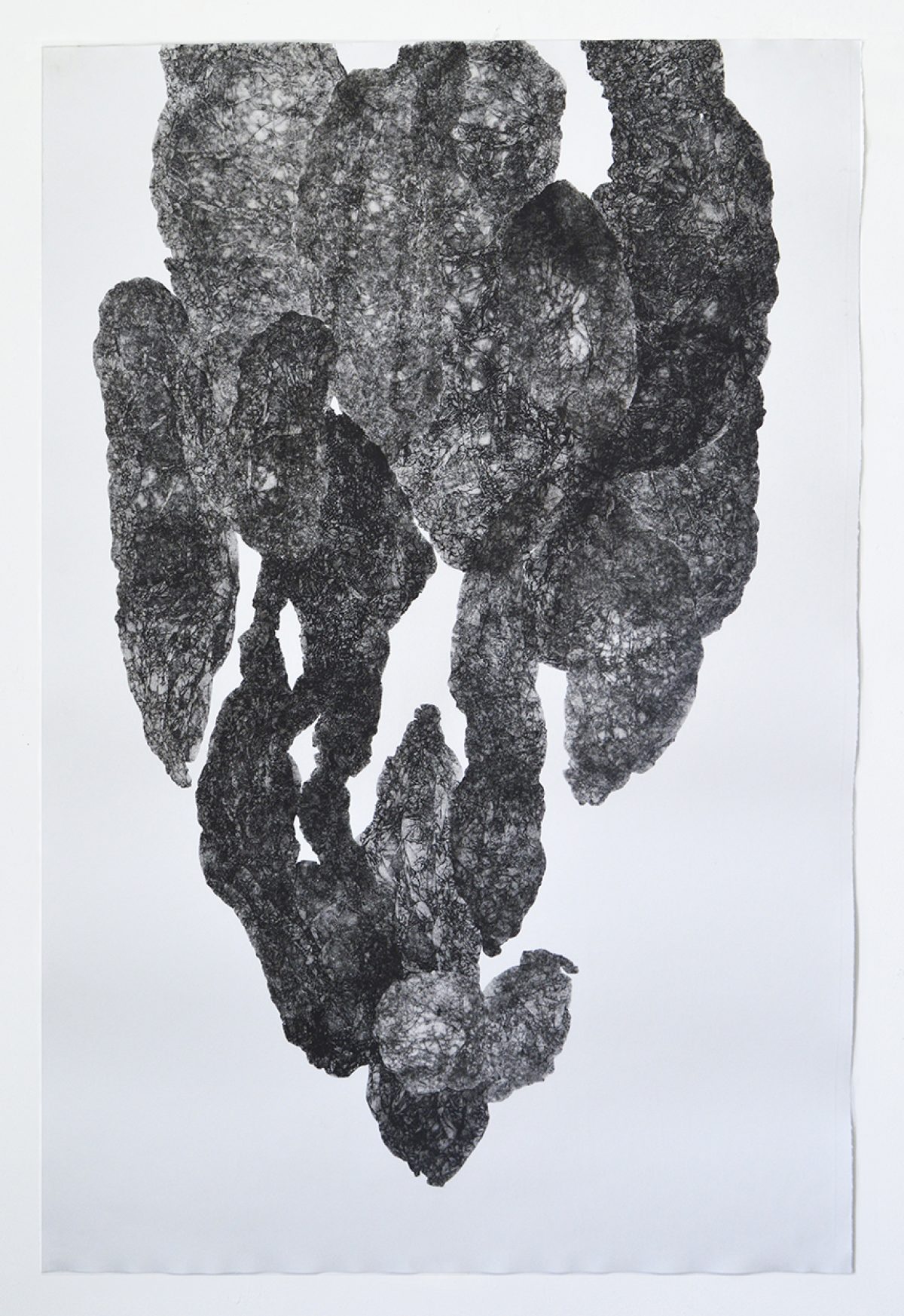 A textured, dark gray monoprint on white paper depicting an abstract, vertical form composed of layered, organic shapes with rough, granular surfaces. The composition suggests fragmented or stacked geological formations, with lighter areas creating depth and contrast throughout the composition.
