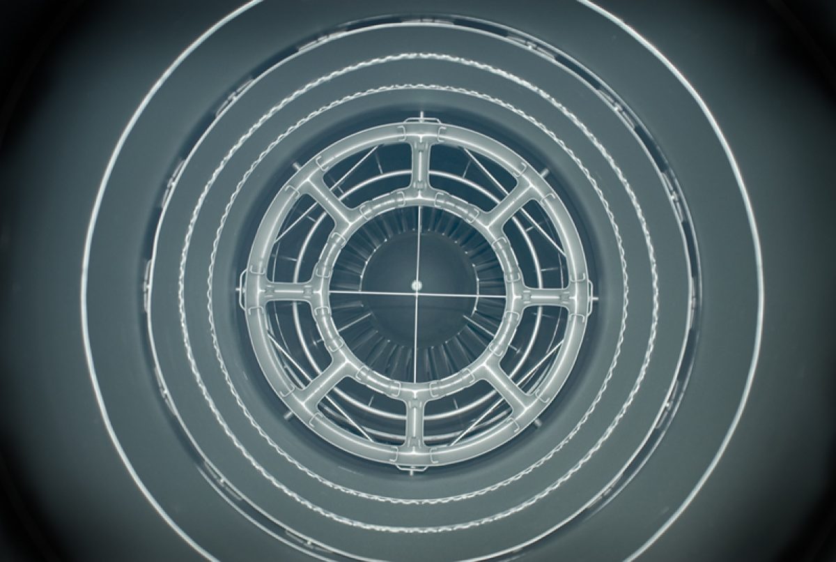 Concentric rings of translucent geometric forms radiate from a central circular structure, creating a tunnel-like perspective. The composition features repeating patterns of architectural or mechanical elements rendered in pale gray and white tones against a darker background, suggesting depth and symmetry.