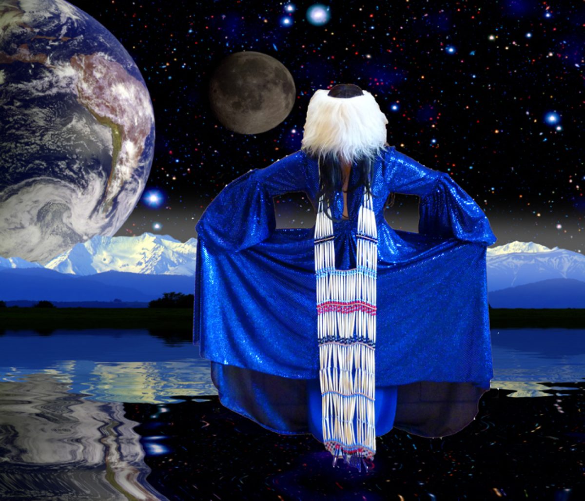 A figure with long white hair viewed from behind stands before a cosmic landscape, wearing a brilliant blue sequined cape over a white beaded garment resembling Big Ben. Earth and moon loom large in a starlit sky above snow-capped mountains reflected in still water below.
