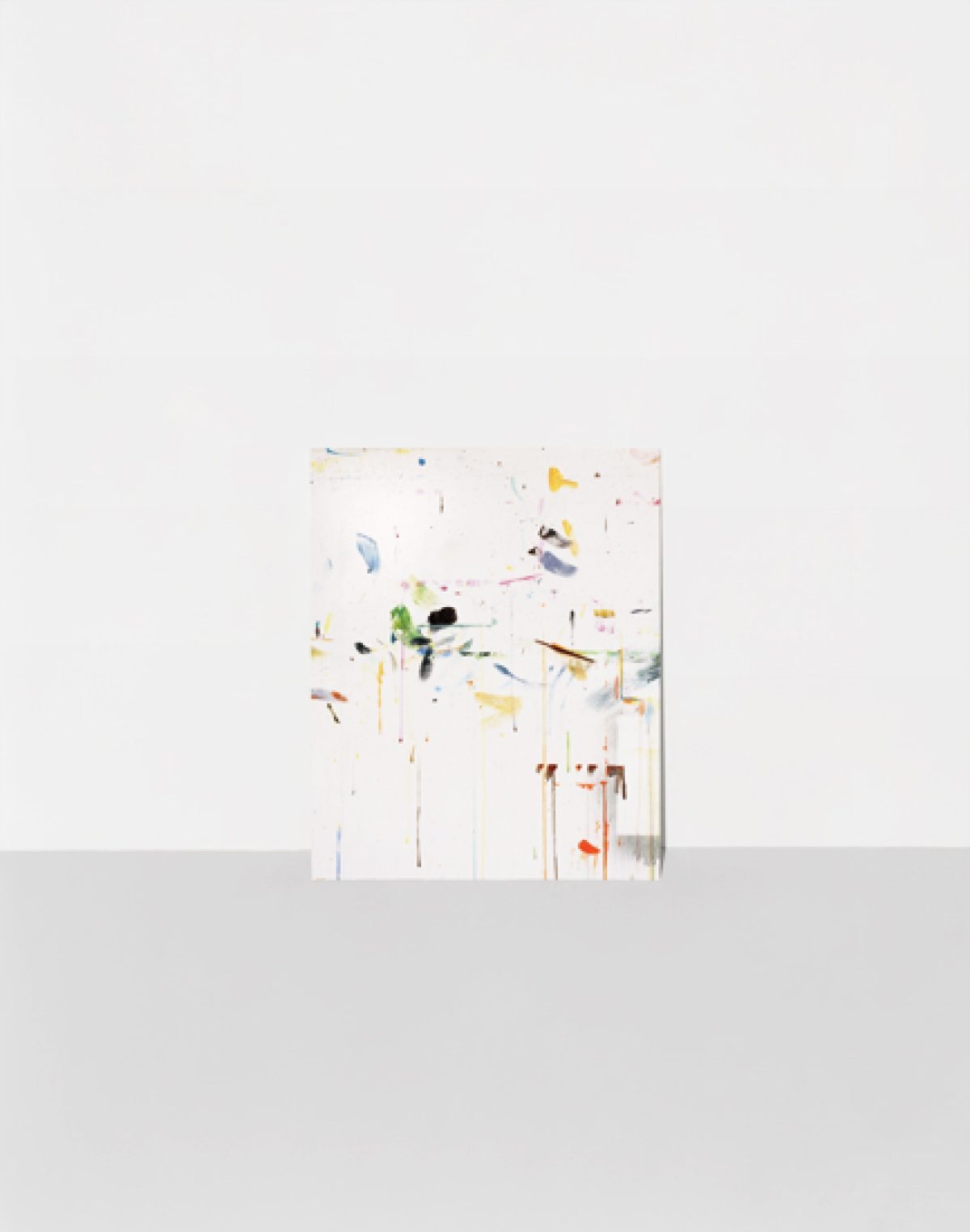 Abstract composition featuring scattered geometric shapes and organic forms in muted yellows, greens, blues, and earth tones arranged across a predominantly white background, creating a sense of dispersed movement and spatial depth.