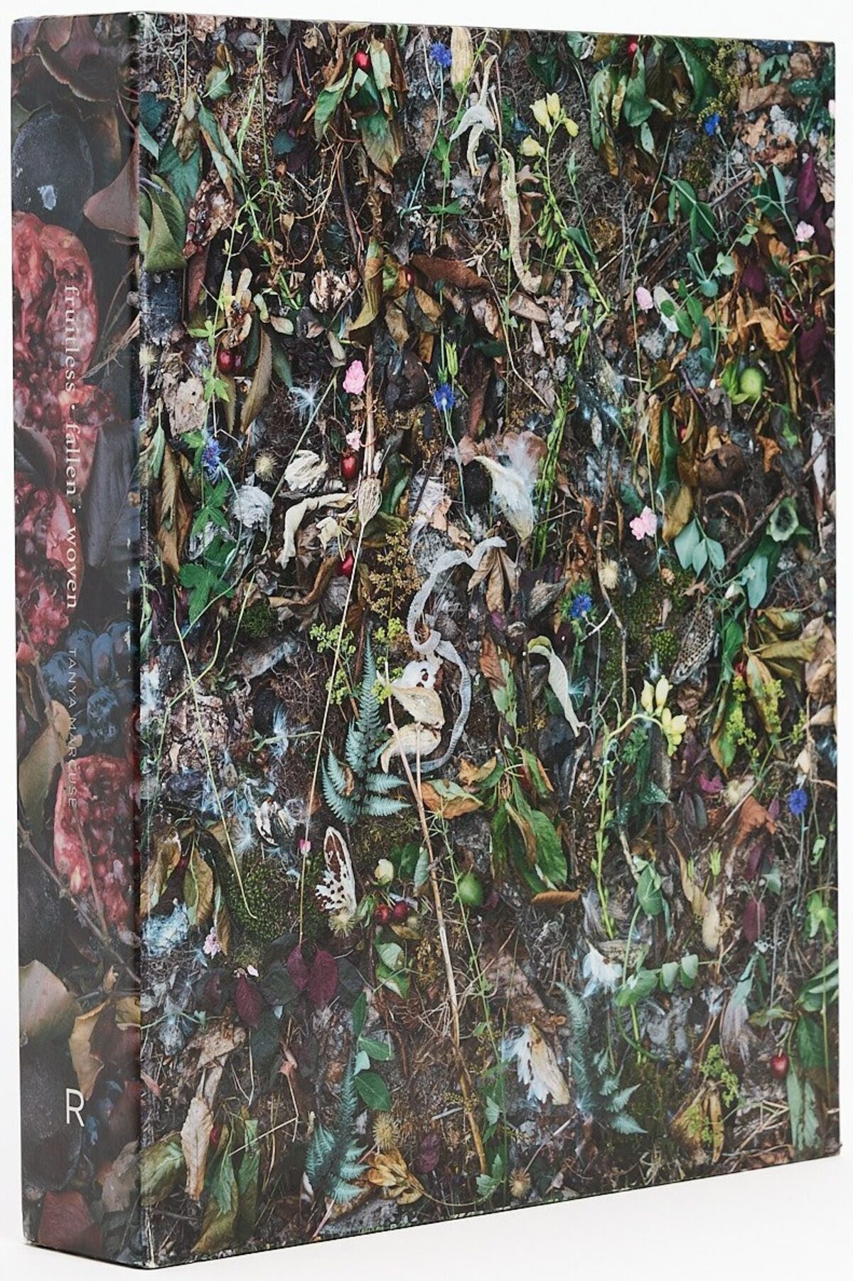 Slipcase for Fruitless | Fallen | Woven by Tanya Marcuse, photographed at an angle, covered in densely arranged plants, fruit, and organic material.