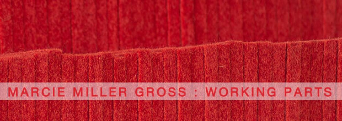 Stacked layers of deep red industrial felt arranged horizontally, creating a textured composition of varying tones and densities. A pale banner with embossed text runs across the center, emphasizing the work's material weight and compressed surface.