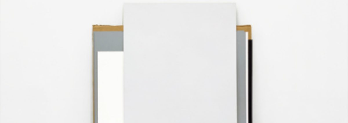 Minimalist composition featuring a white rectangular panel suspended between two vertical metal frames with wood and dark accents, set against a neutral background. The geometric intervention questions spatial perception through stark contrast between the inserted form and its surrounding environment.