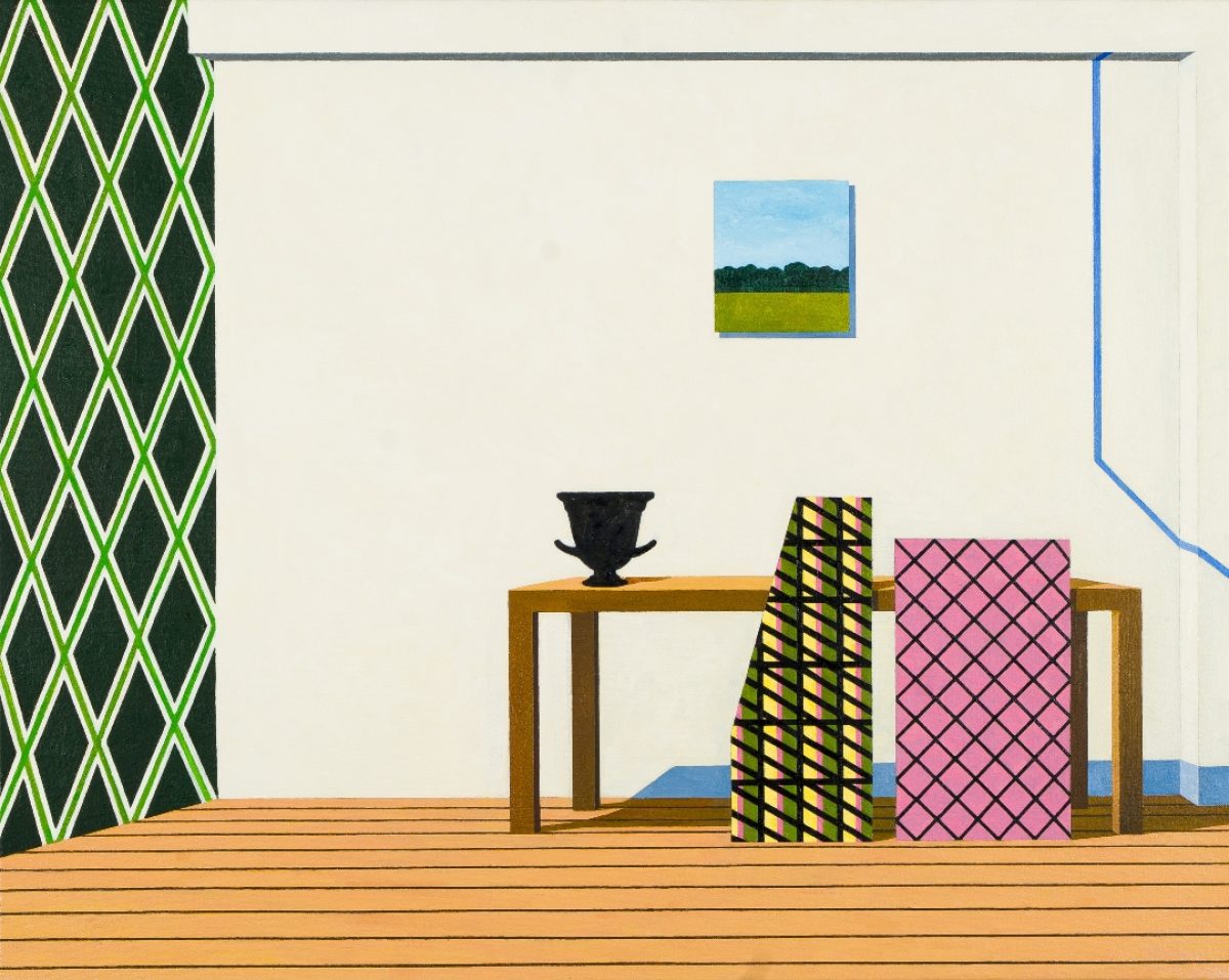 A staged interior composition featuring a wooden floor and cream-colored wall decorated with a green and yellow diamond-patterned panel on the left. A wooden table displays a black classical urn, flanked by geometric forms in black-and-yellow stripes and pink quilted patterns. A landscape painting depicting a yellow field and tree line hangs above, while a blue architectural element frames the upper right corner.