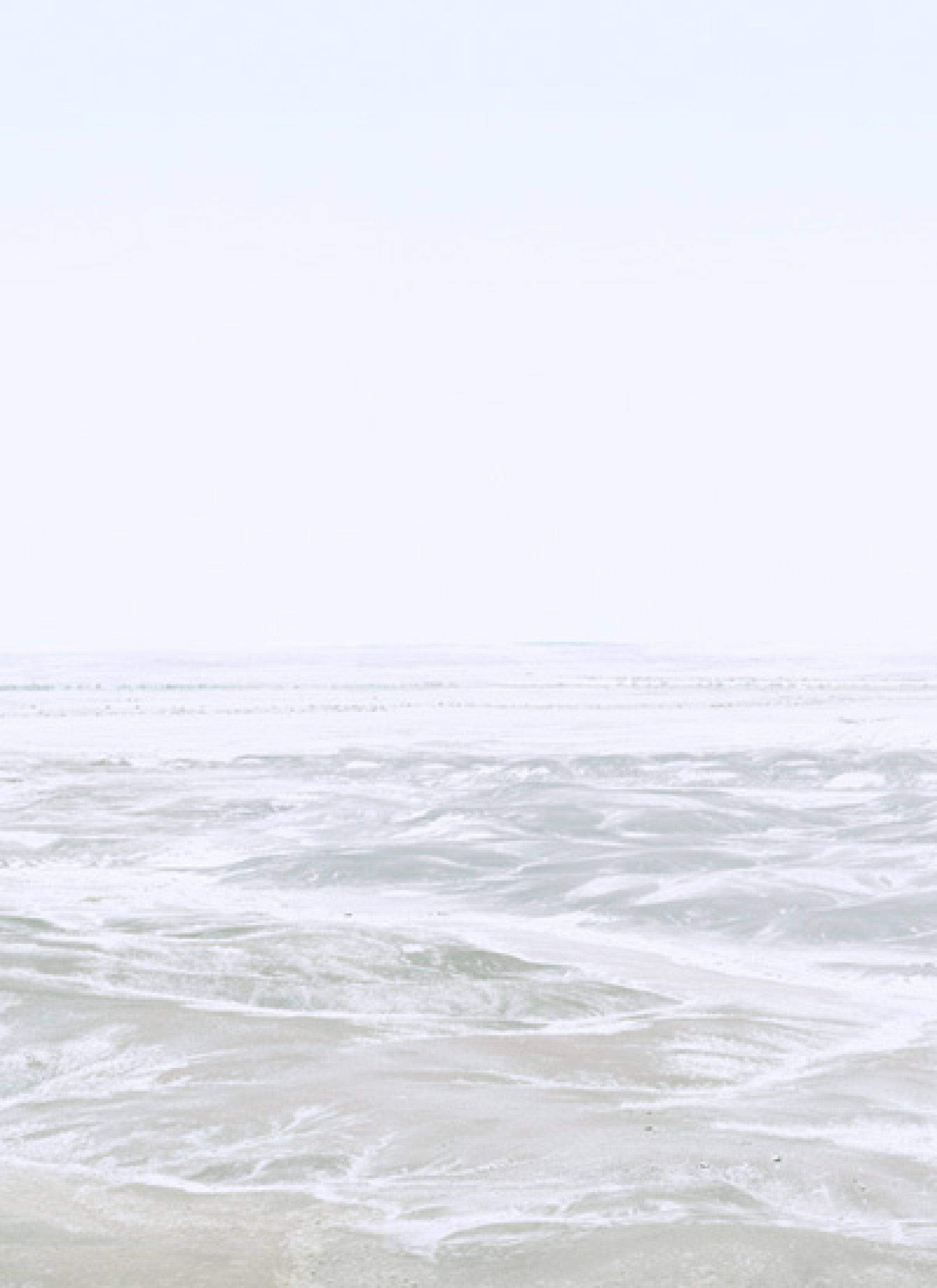 Soft, hazy seascape with gentle waves and foam washing onto a pale sandy beach beneath an overcast sky, rendered in muted tones of white, gray, and soft green in a minimalist composition.