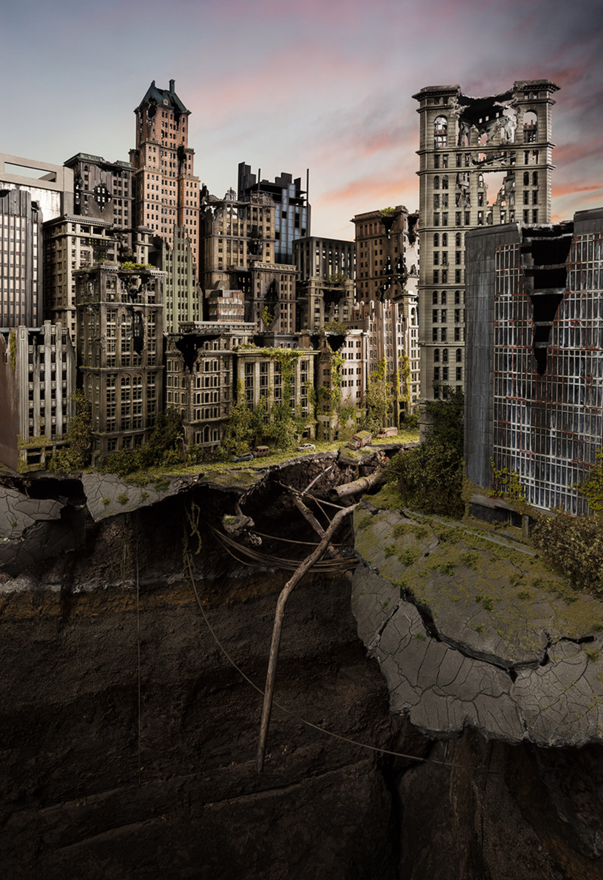 A post-apocalyptic cityscape depicting abandoned skyscrapers overtaken by vegetation and decay, with cracked pavement, rusted debris, and gnarled branches scattered across barren ground in the foreground. Soft golden and pink light illuminates the deteriorating Art Deco and early modernist architecture against a dusky sky, creating a haunting contrast between urban grandeur and nature reclaiming the built environment.