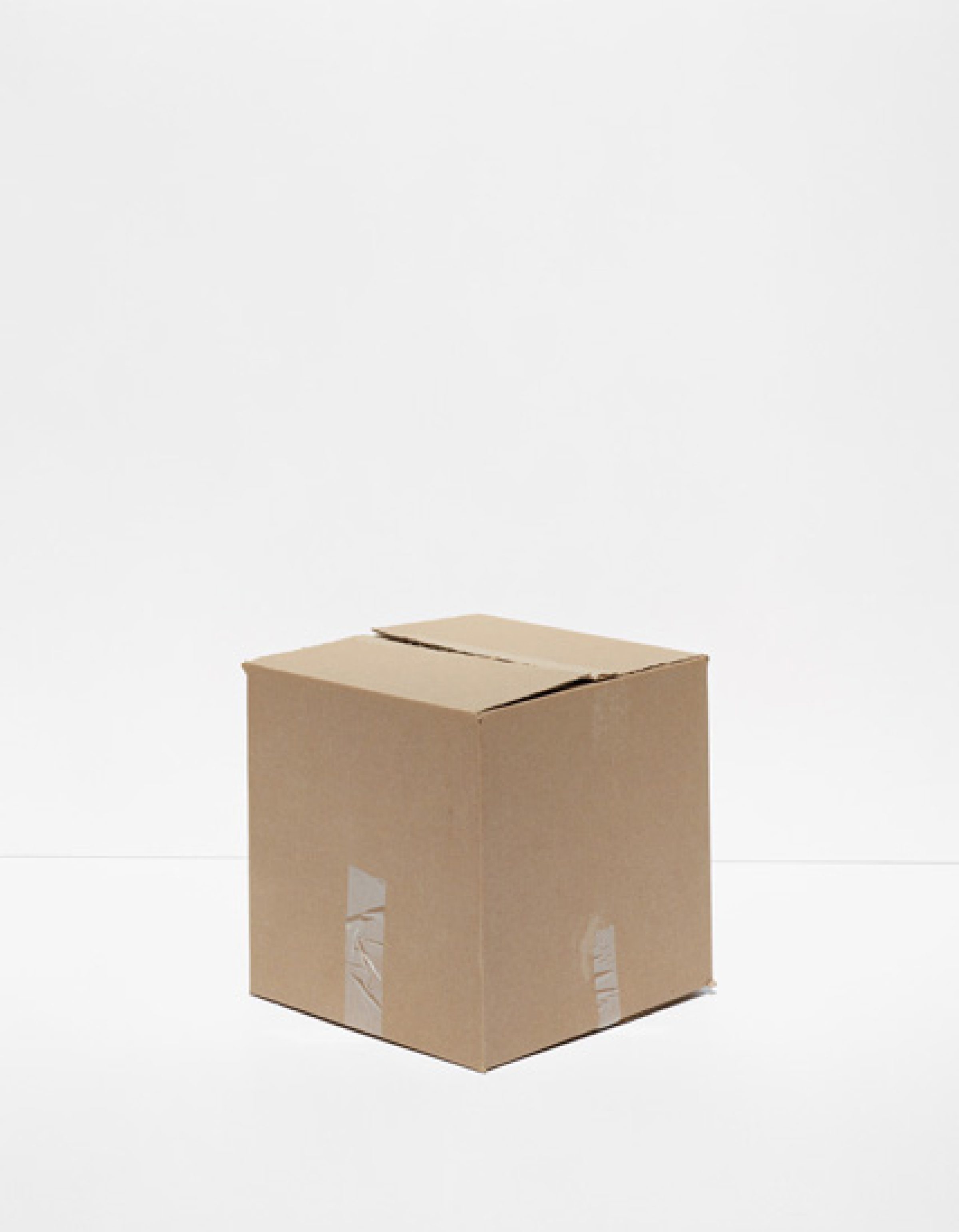 A tan cardboard shipping box photographed centrally against a neutral gray background, with visible clear packing tape on two sides and a slot cut into the top.