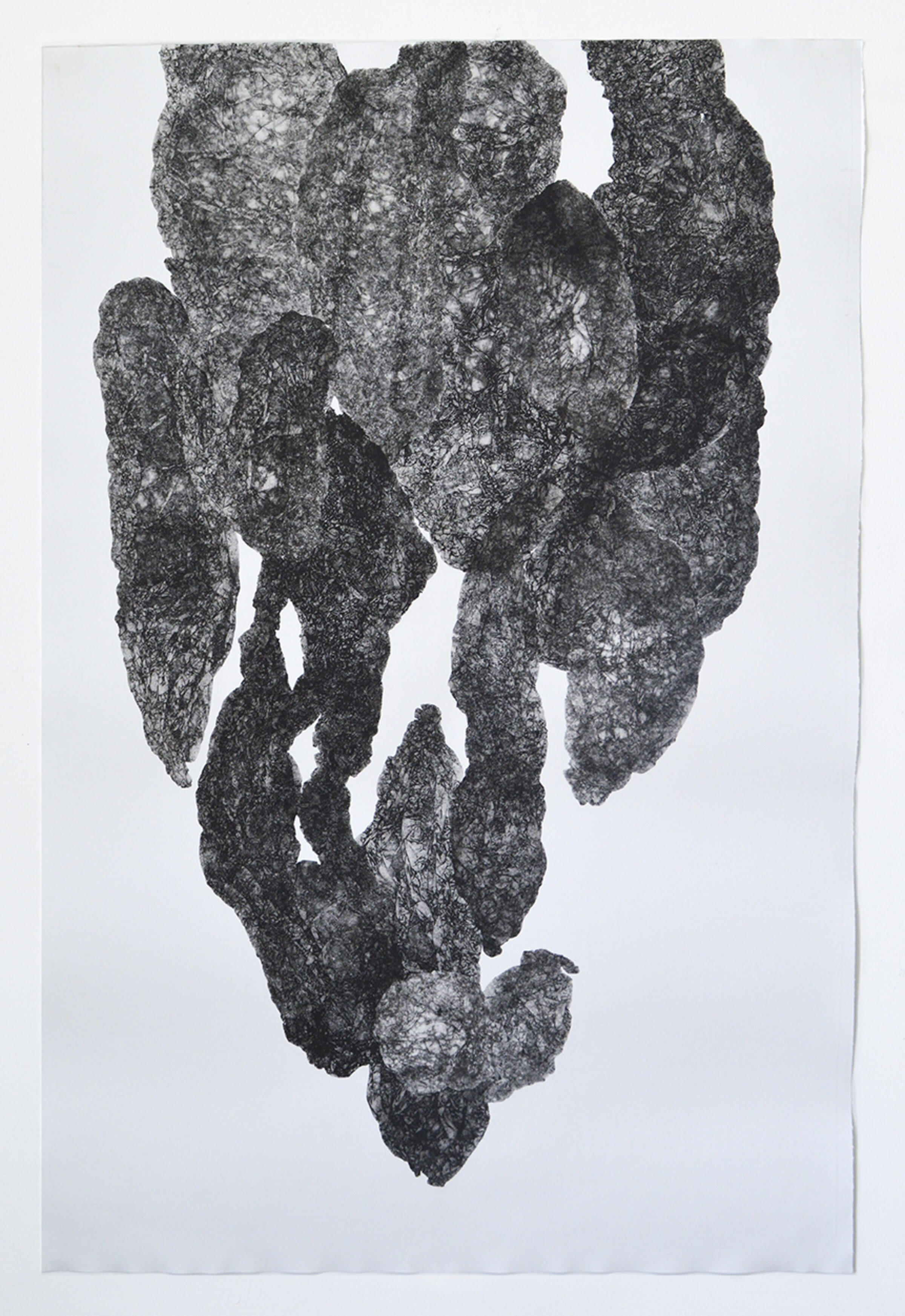 A textured, dark gray monoprint on white paper depicting an abstract, vertical form composed of layered, organic shapes with rough, granular surfaces. The composition suggests fragmented or stacked geological formations, with lighter areas creating depth and contrast throughout the composition.