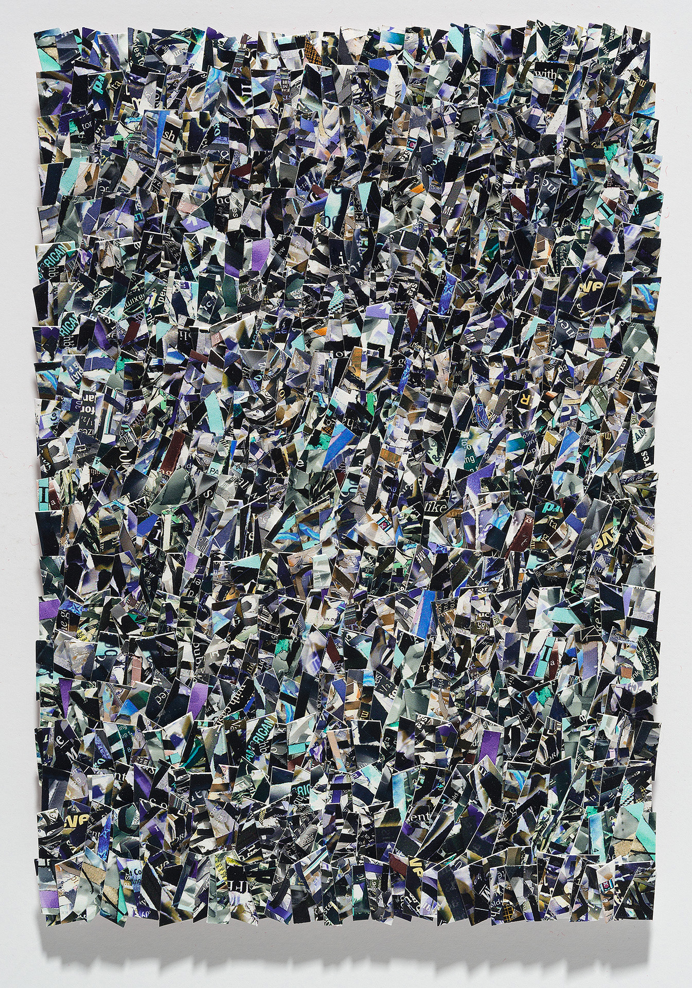 A densely layered collage of hundreds of torn and overlapping printed fragments in shades of black, white, purple, blue, cyan, and gold, creating an all-over abstract composition with no clear focal point. The irregular paper pieces are arranged in a chaotic, non-representational pattern across a rectangular format, with visible text and imagery fragments scattered throughout the surface.
