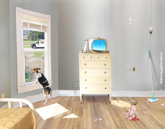 A bright, sunlit domestic interior with warm wood flooring features a yellow dresser topped with a vintage television displaying a blue sky image, alongside white ceramic vessels and hanging pendant lights. In the foreground, a dog peers through an open door toward the exterior, while a child in pink sits on the floor near cleaning supplies, and another figure rests on a bed in the lower left, creating a layered scene of everyday domestic life.