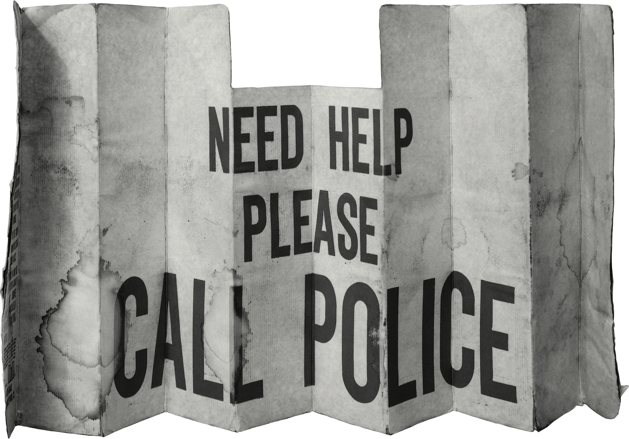 A weathered, accordion-folded metal panel resembling a car windshield sun shade, printed with bold black text reading "NEED HELP PLEASE CALL POLICE." The surface shows creasing, discoloration, and wear consistent with prolonged outdoor use.