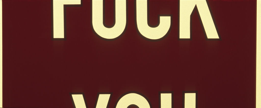 Bold cream-colored capital letters set against a deep burgundy background, with partial text visible at the top and bottom of the composition. The stark typographic design employs a classic serif typeface with strong geometric forms and high contrast between the vibrant text and dark field.