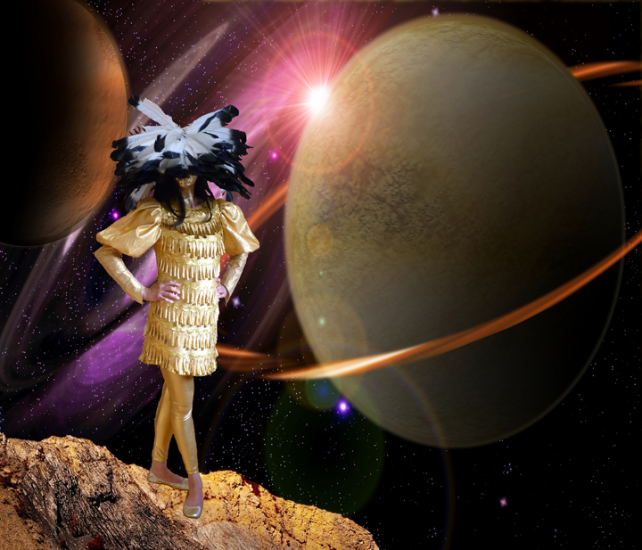 A figure in a shimmering gold pleated dress stands on a rocky outcrop against a cosmic background, holding an elaborate black sculptural headdress aloft. Massive planets with golden orbital rings dominate the surrounding space, while pink and purple light radiates from a distant star, creating a surreal, otherworldly composition that blends earthly and celestial elements.