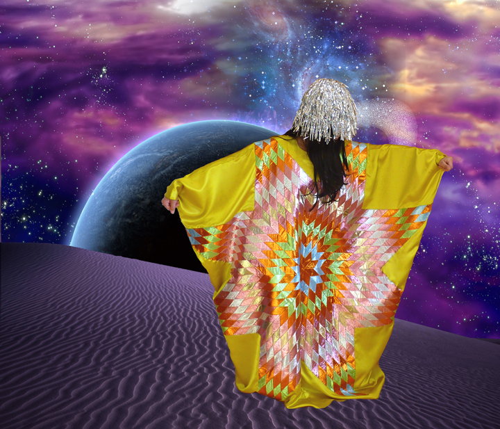 A figure with long white hair stands on a rippled desert landscape wearing a vibrant yellow garment with geometric patterns in orange, red, and white. Behind them, a glowing planet hovers against a cosmic sky of purple, blue, and golden clouds scattered with stars.