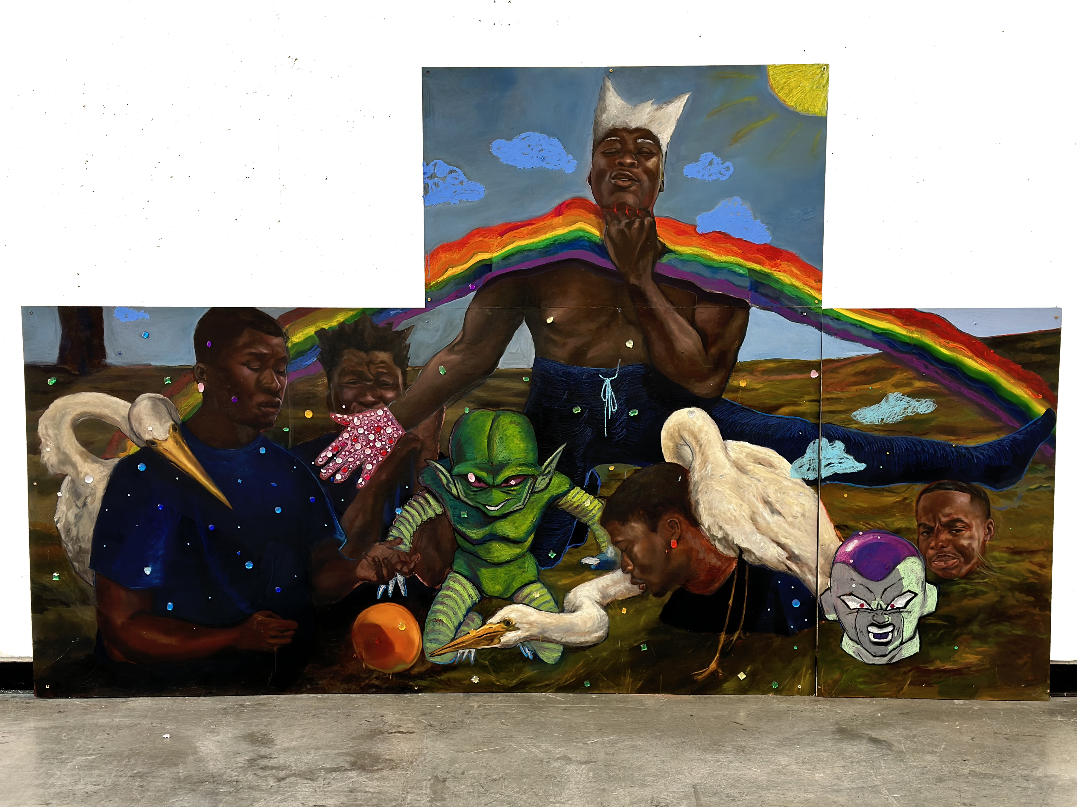 A vibrant multi-panel mural depicting Black figures with wings alongside fantastical creatures including a green alien and a purple-faced character, set against a landscape with a rainbow, sun, and scattered gemstone embellishments. The composition blends realistic portraiture with surreal imagery in bold colors and layered paint application.