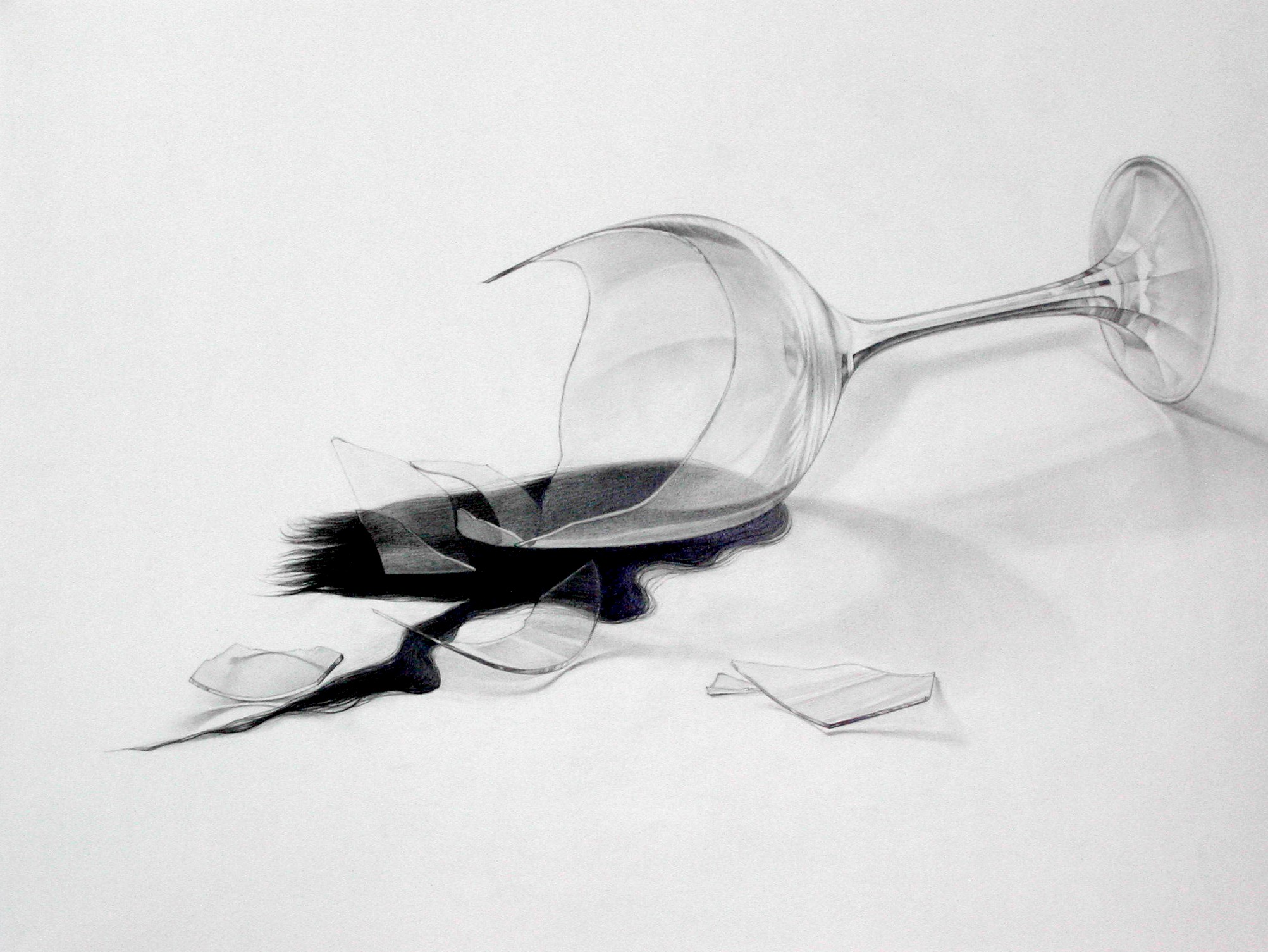 A tipped-over wine glass with dark liquid spilling across a white surface, rendered in graphite with careful attention to transparency, reflection, and shadow. Broken glass shards scatter nearby, creating a study in contrast between the delicate clarity of the glass vessel and the bold, gestural marks of the spilled liquid.