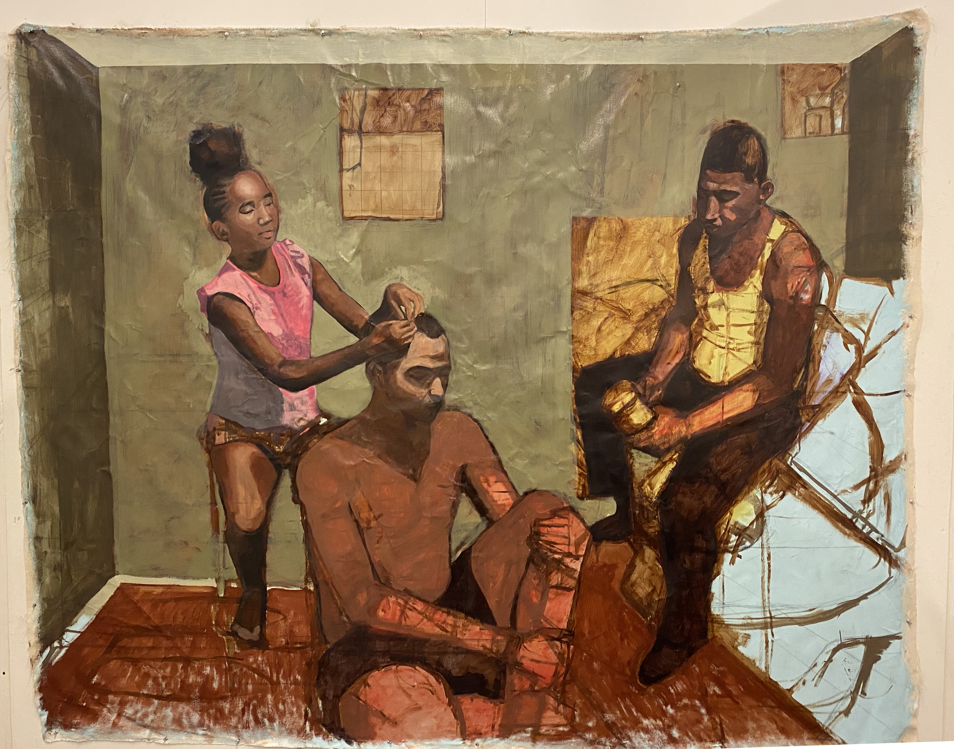 A domestic interior scene depicting three figures with warm brown skin tones arranged in a sparse room with pale green walls and a reddish-brown floor. A woman in a pink sleeveless shirt stands behind a seated shirtless man, braiding his hair, while another man in a yellow vest stands to the right holding what appears to be a mirror or reflective object. The composition uses rich ochre and golden tones in the figures' clothing and skin, contrasted against the muted background, rendered in an expressive painterly style.