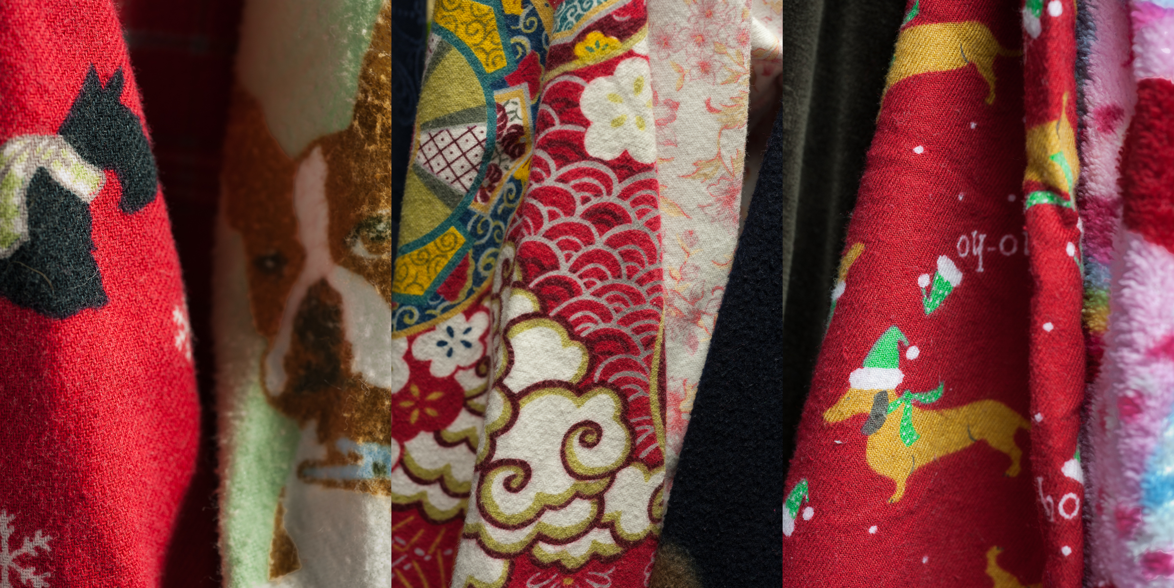 Close-up view of folded textile strips displaying holiday and festive patterns in red, cream, gold, and dark colors. The fabrics feature various designs including Christmas trees with Santa hats, ornamental scrollwork, snowflakes, and decorative geometric borders, arranged vertically to show the layered, tactile quality of the printed cotton materials.
