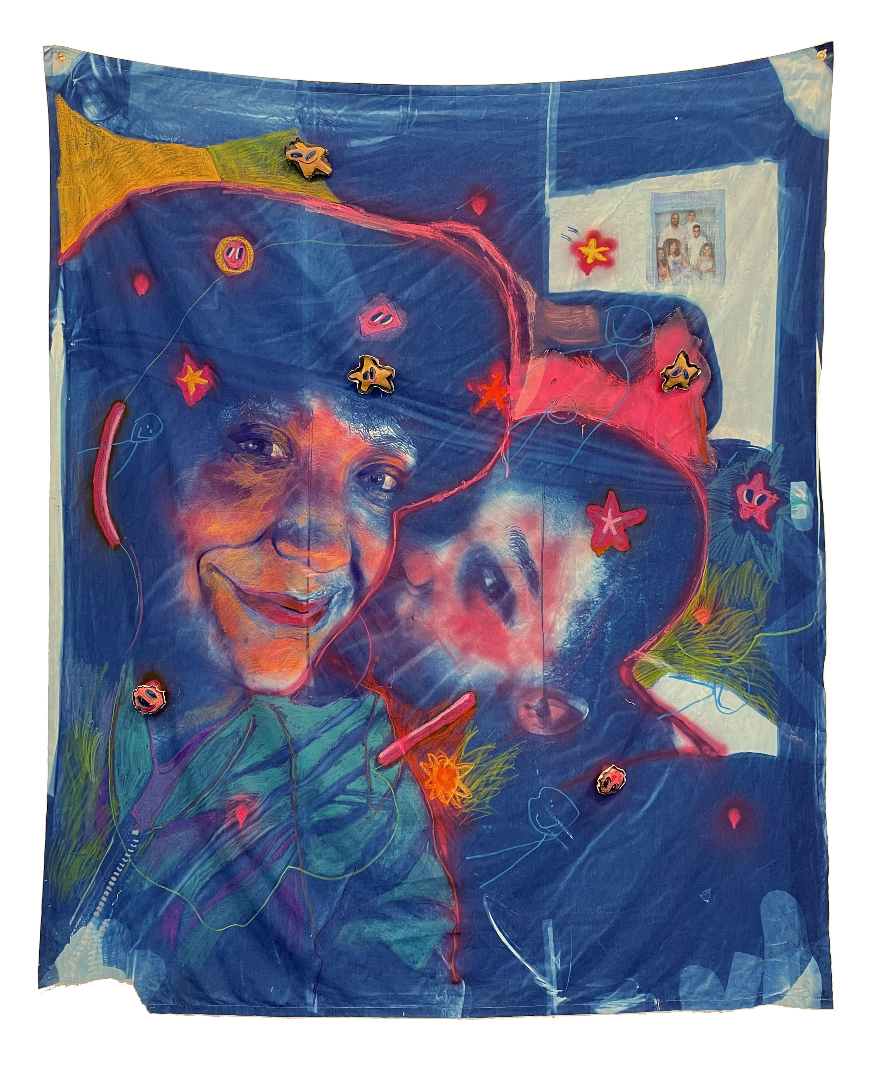 Large textile work on deep blue cotton featuring two portraits rendered in warm oranges, reds, and yellows with expressive, gestural line work. The composition includes scattered stars, flowing green botanical elements, and small photograph collage elements in the upper right, with red outlines creating dynamic movement across the surface.