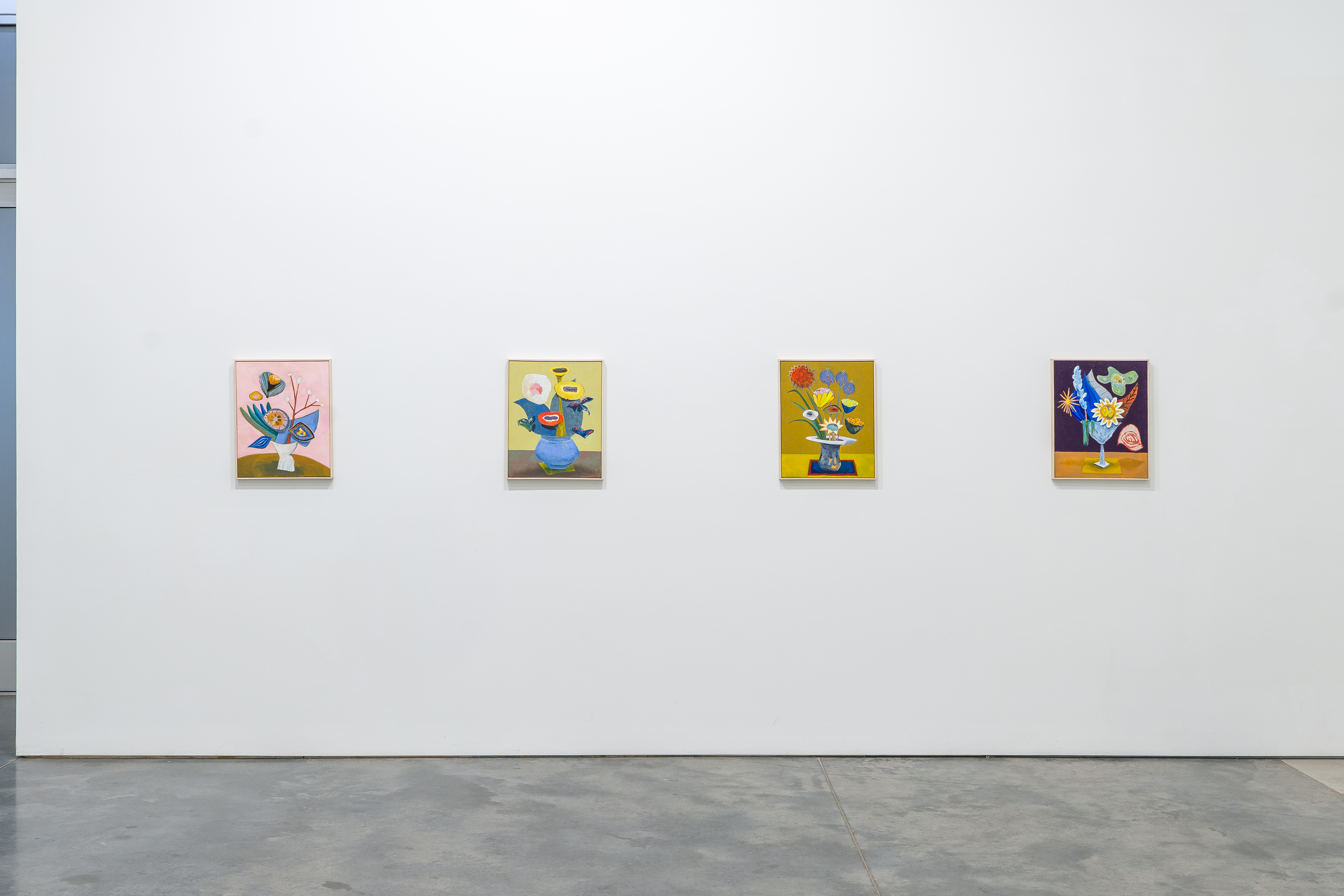 Four small paintings arranged horizontally on a white gallery wall, each depicting stylized floral arrangements in ceramic vessels against colorful backgrounds. The works feature vibrant hues—pink, yellow, gold, and deep purple—with playful, organic forms rendered in a contemporary illustrative style that blends botanical imagery with abstract elements.