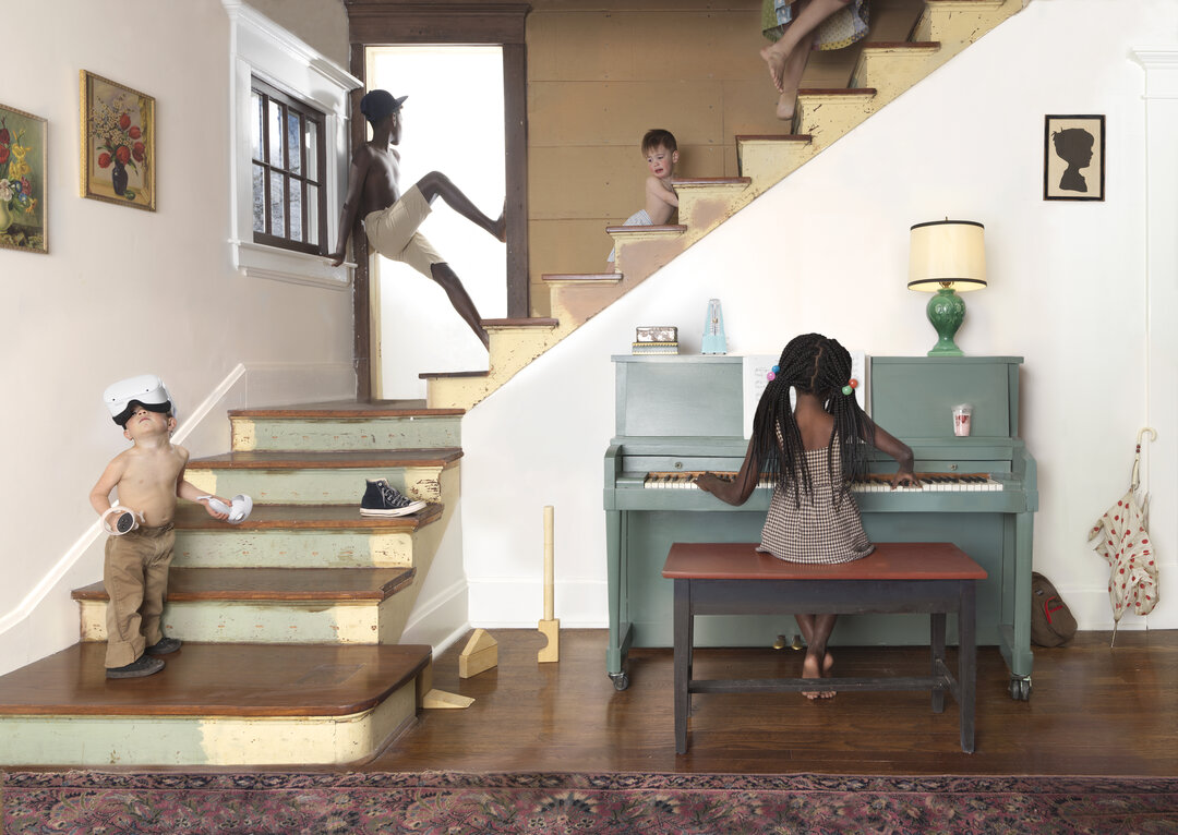 A staged domestic interior scene featuring multiple figures of varying scales positioned throughout a living space with stairs, featuring a child at a piano, a young child on the staircase, and silhouetted figures at different elevations. The composition uses warm cream and pale yellow tones with sage green accents, combining realistic and surreal spatial relationships within a single room.