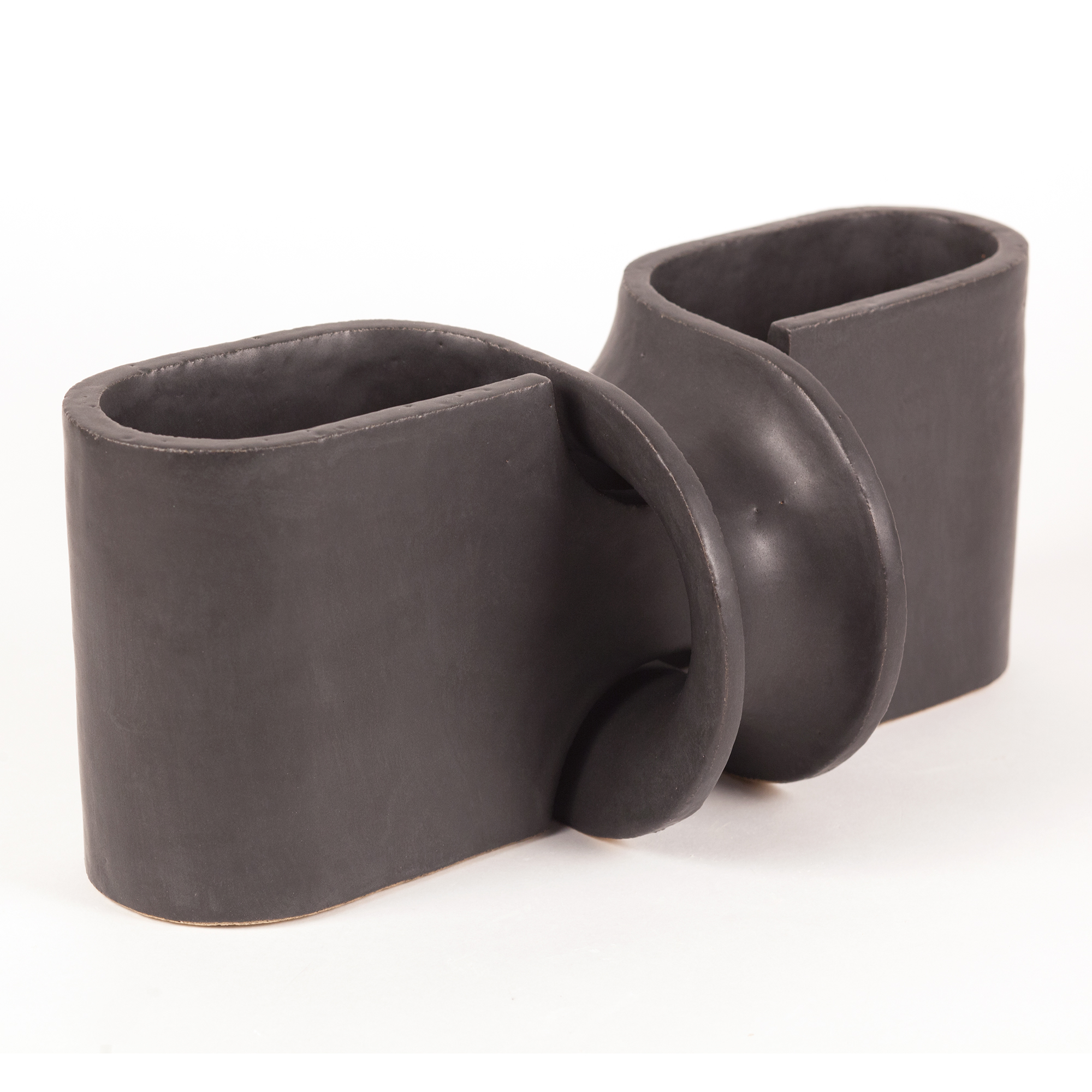 Three dark gray ceramic vessels with organic, undulating forms arranged in a row. The cylindrical cups feature curved, bulbous protrusions along their sides, creating an abstract sculptural quality. Matte glaze finish with subtle tonal variations across the smooth surfaces.