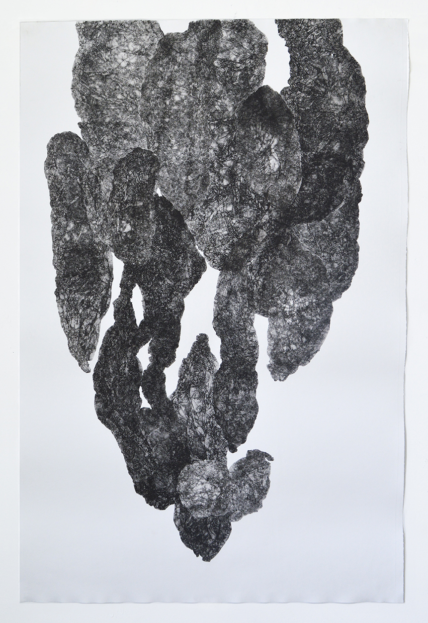 A textured, dark gray monoprint on white paper depicting an abstract, vertical form composed of layered, organic shapes with rough, granular surfaces. The composition suggests fragmented or stacked geological formations, with lighter areas creating depth and contrast throughout the composition.