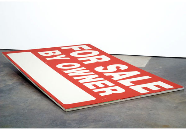 A large red and white canvas laid flat on a gallery floor features bold white sans-serif text reading "FOR SALE" arranged diagonally across the composition, with additional smaller text partially visible along the left edge.
