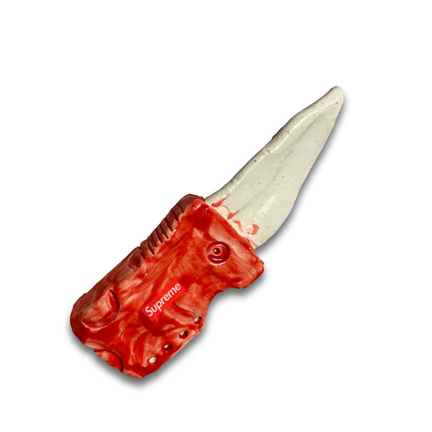 A ceramic folding knife with a bright red handle featuring embossed detailing and a cream-colored blade with metallic luster, photographed against a white background.
