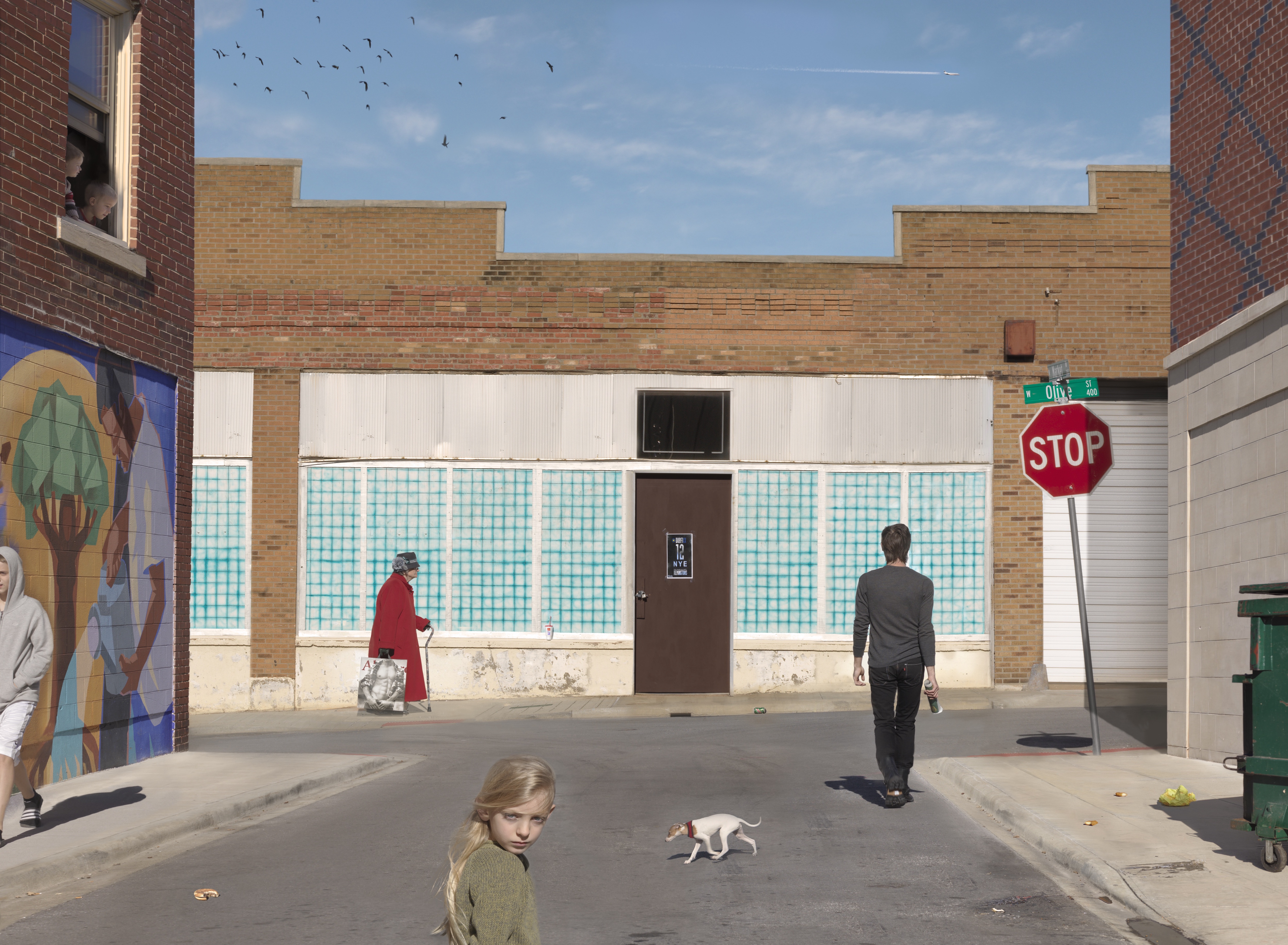 An urban alleyway framed by brick buildings features several figures and a small white dog in the street. The composition includes a mural on the left wall, a turquoise and white tiled storefront in the center, and a red STOP sign on the right, with birds flying in the clear blue sky above.