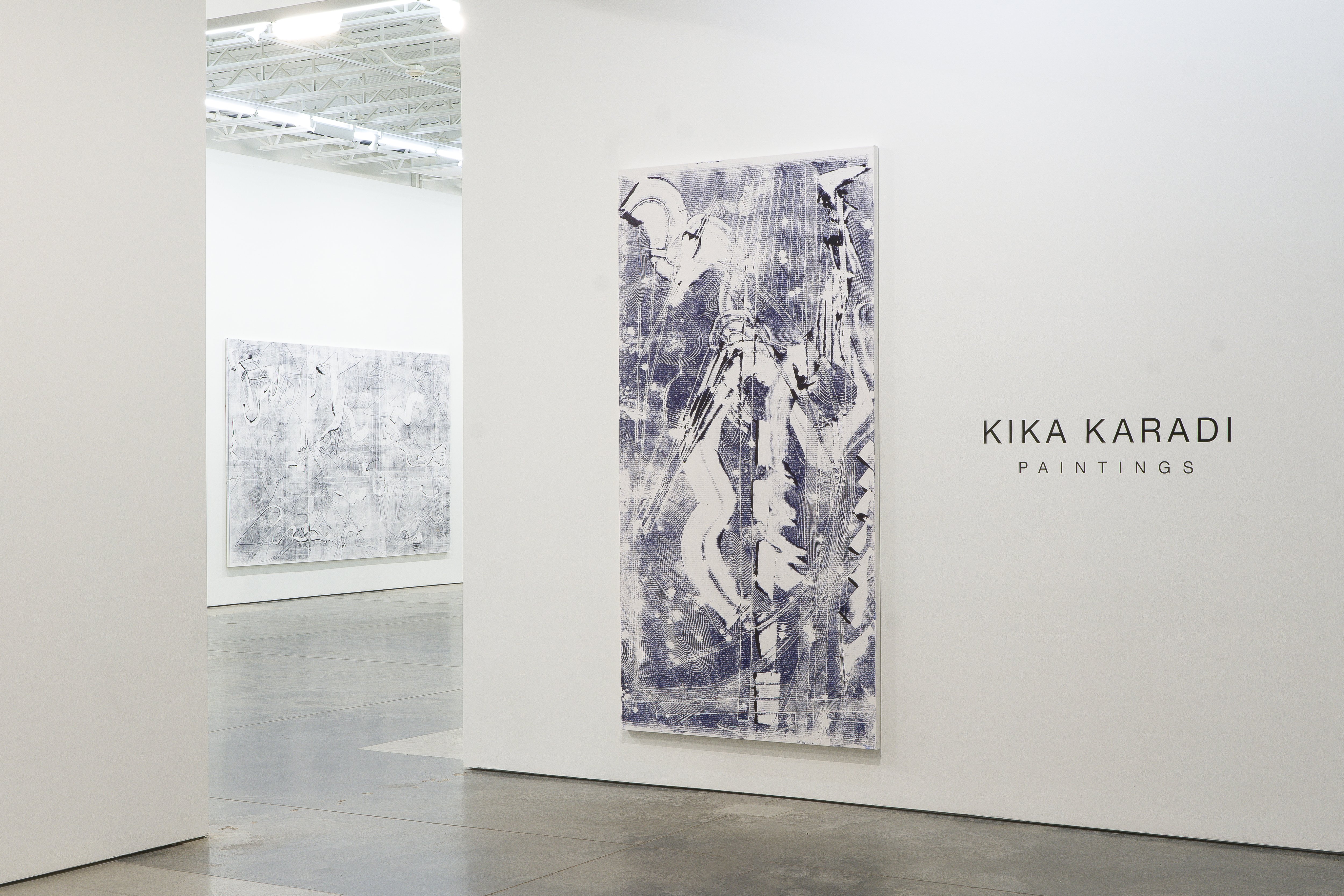 Large-scale monochromatic painting on canvas featuring gestural abstract marks, layered textures, and organic forms rendered in deep blue and white tones. The composition displays expressive brushwork and scraped surfaces creating a sense of depth and movement across the vertical canvas.