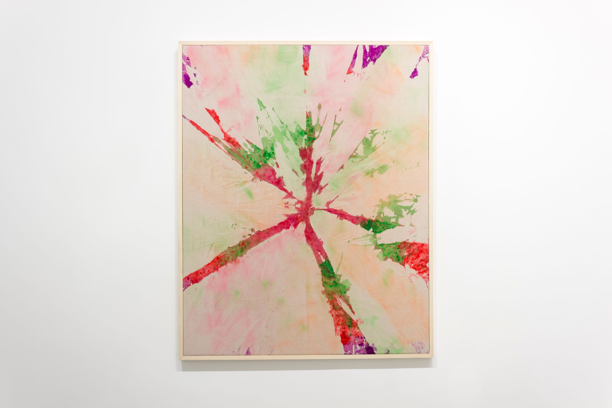 Abstract watercolor painting with a radial composition featuring vibrant splashes of red, pink, green, and purple emanating from a central point, creating a dynamic starburst pattern against a soft, blended background of cream and pale yellow tones.