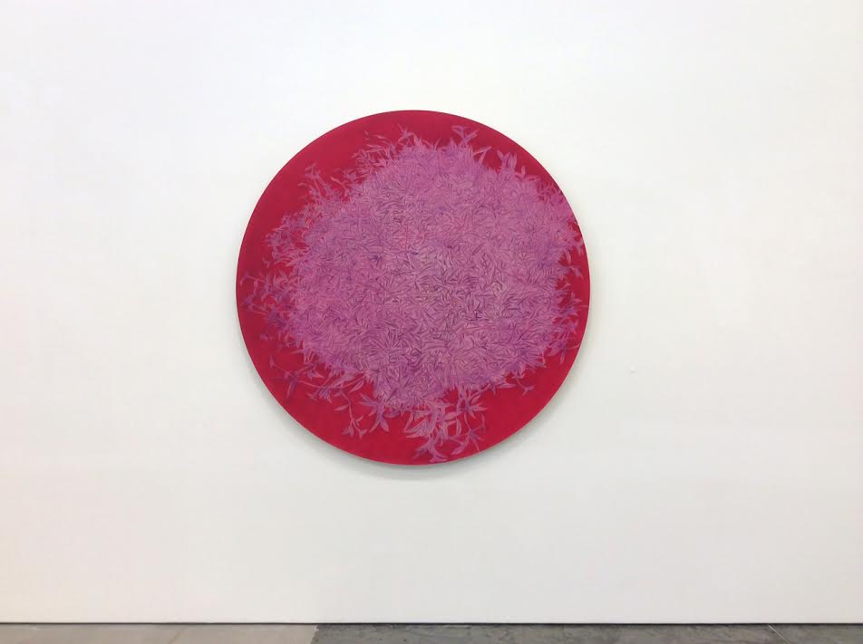 A circular painting with a vibrant magenta outer border that gradually transitions to muted mauve tones toward the center, creating a soft gradient effect. The surface appears flat and matte with delicate, intricate linear patterns throughout, suggesting an abstracted natural or landscape imagery rendered in a brushless technique.