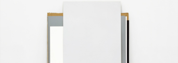 Minimalist composition featuring a white rectangular panel suspended between two vertical metal frames with wood and dark accents, set against a neutral background. The geometric intervention questions spatial perception through stark contrast between the inserted form and its surrounding environment.